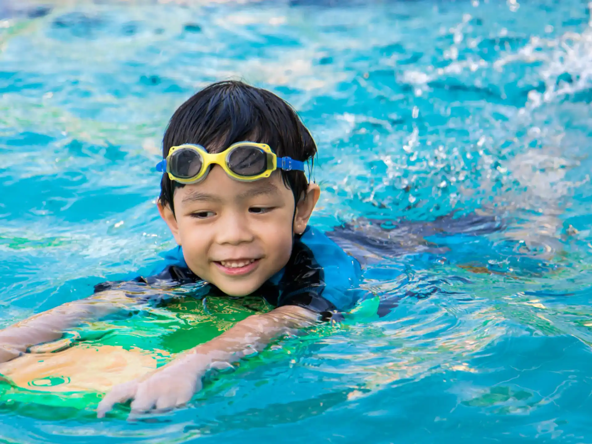 a boy wearing goggles in a pool
