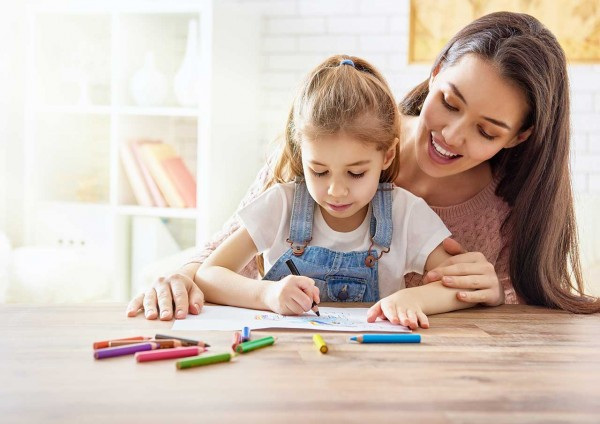 a person and a child coloring on a table