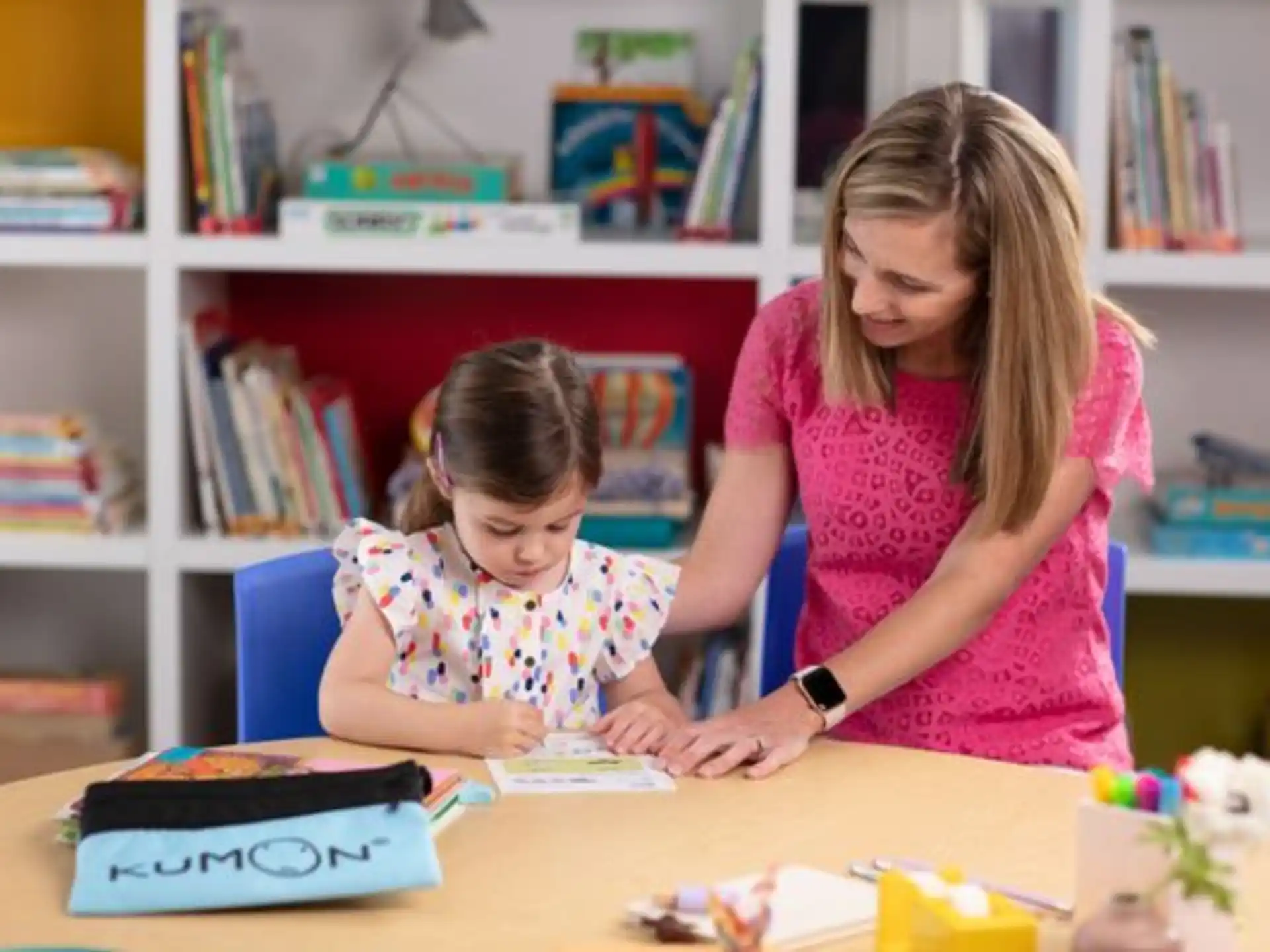 a person and a child looking at a book