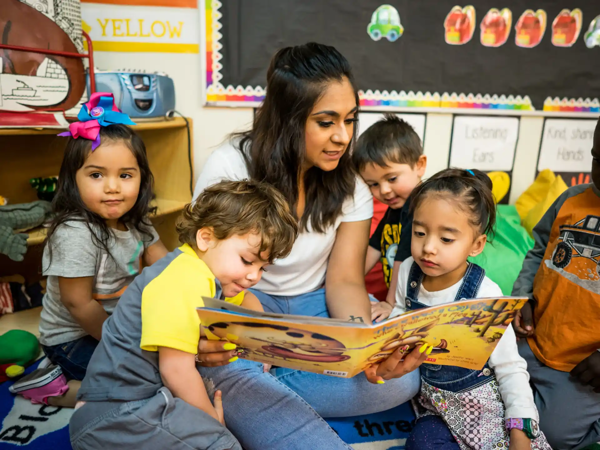 a person reading a book to a group of children