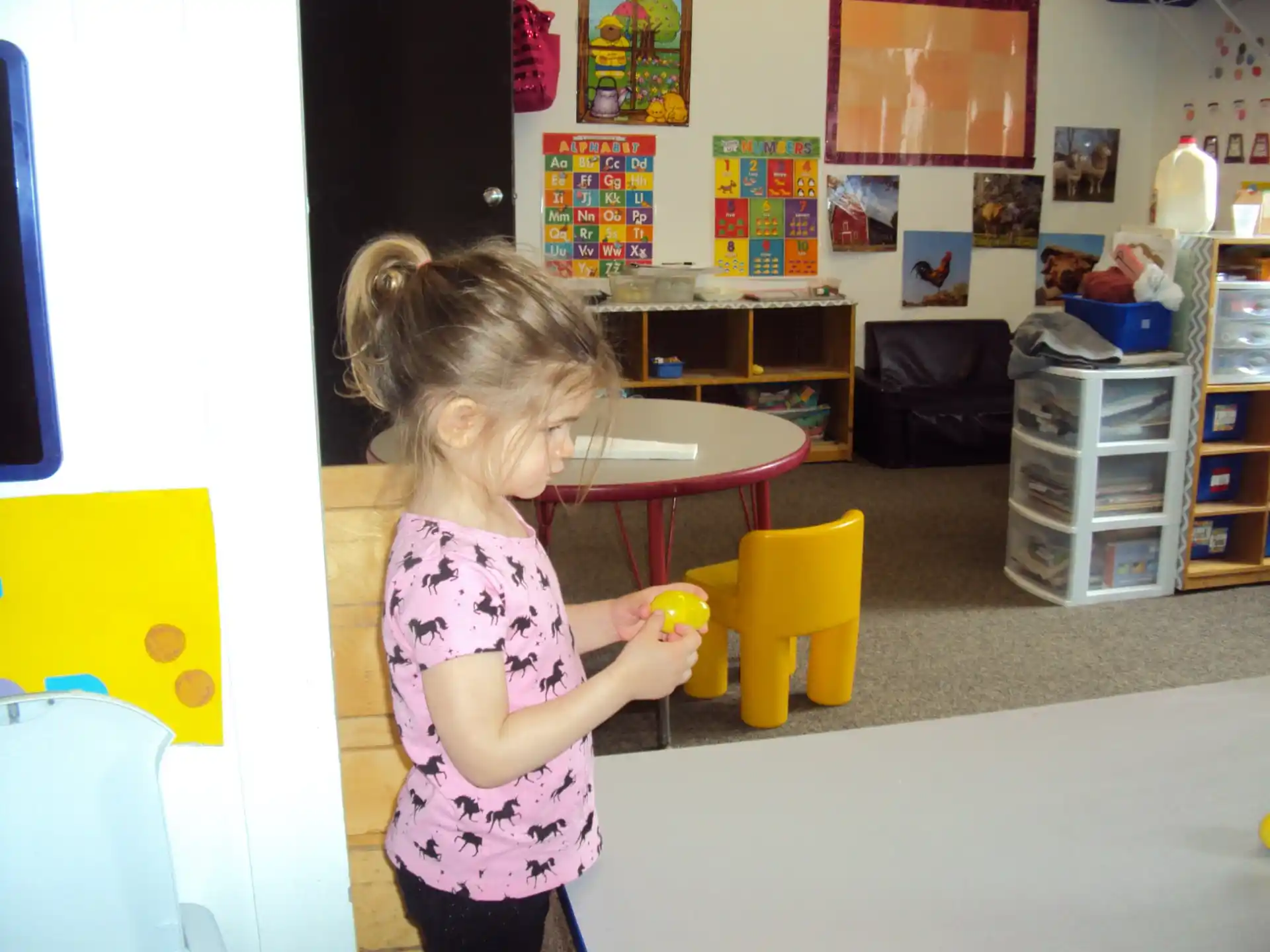 a little girl holding a toy