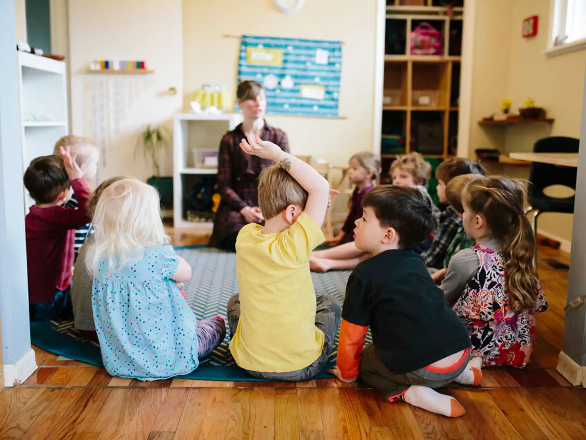 a group of children sitting on the floor in a classroom