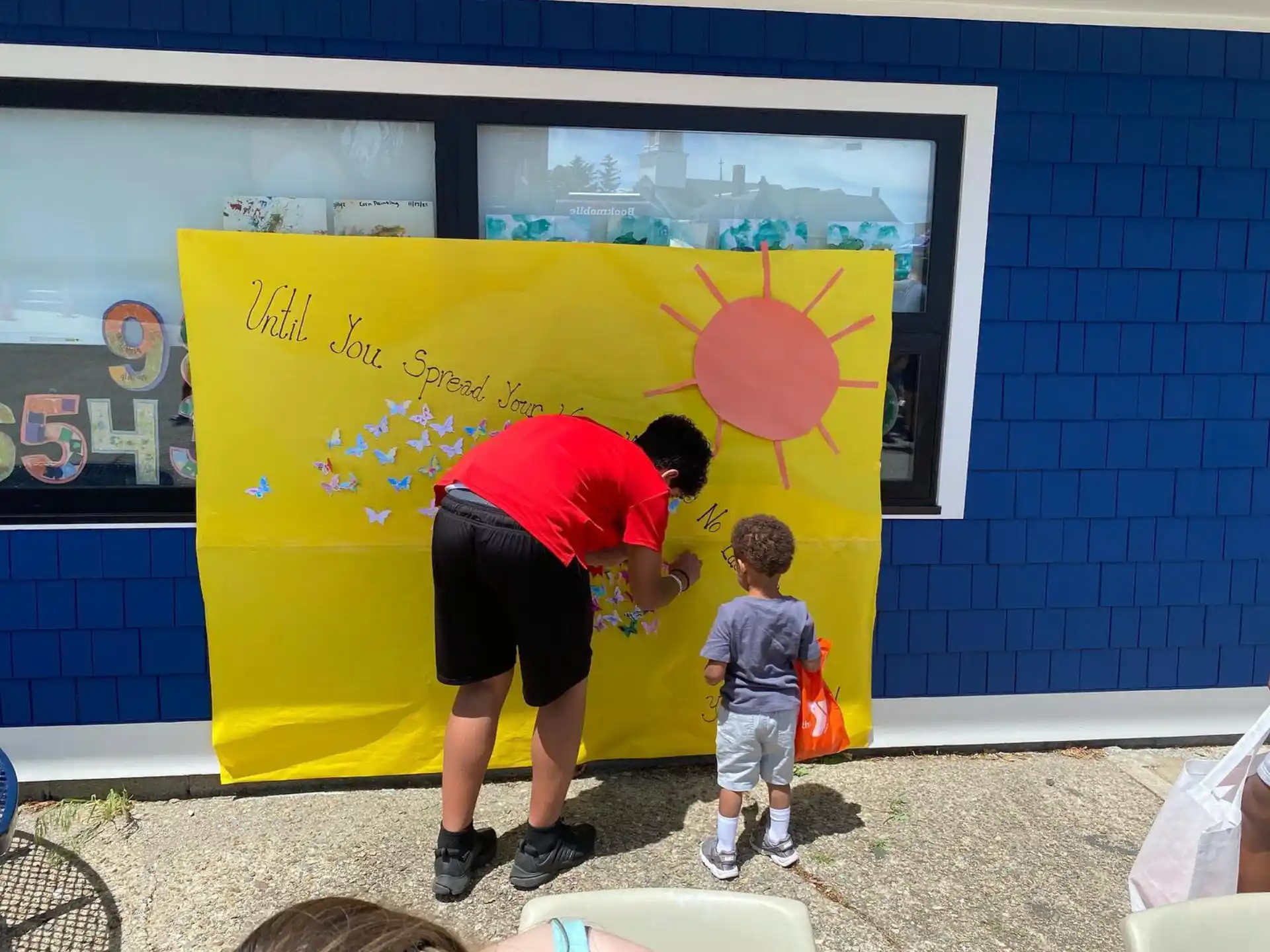 a person and a boy standing in front of a mural