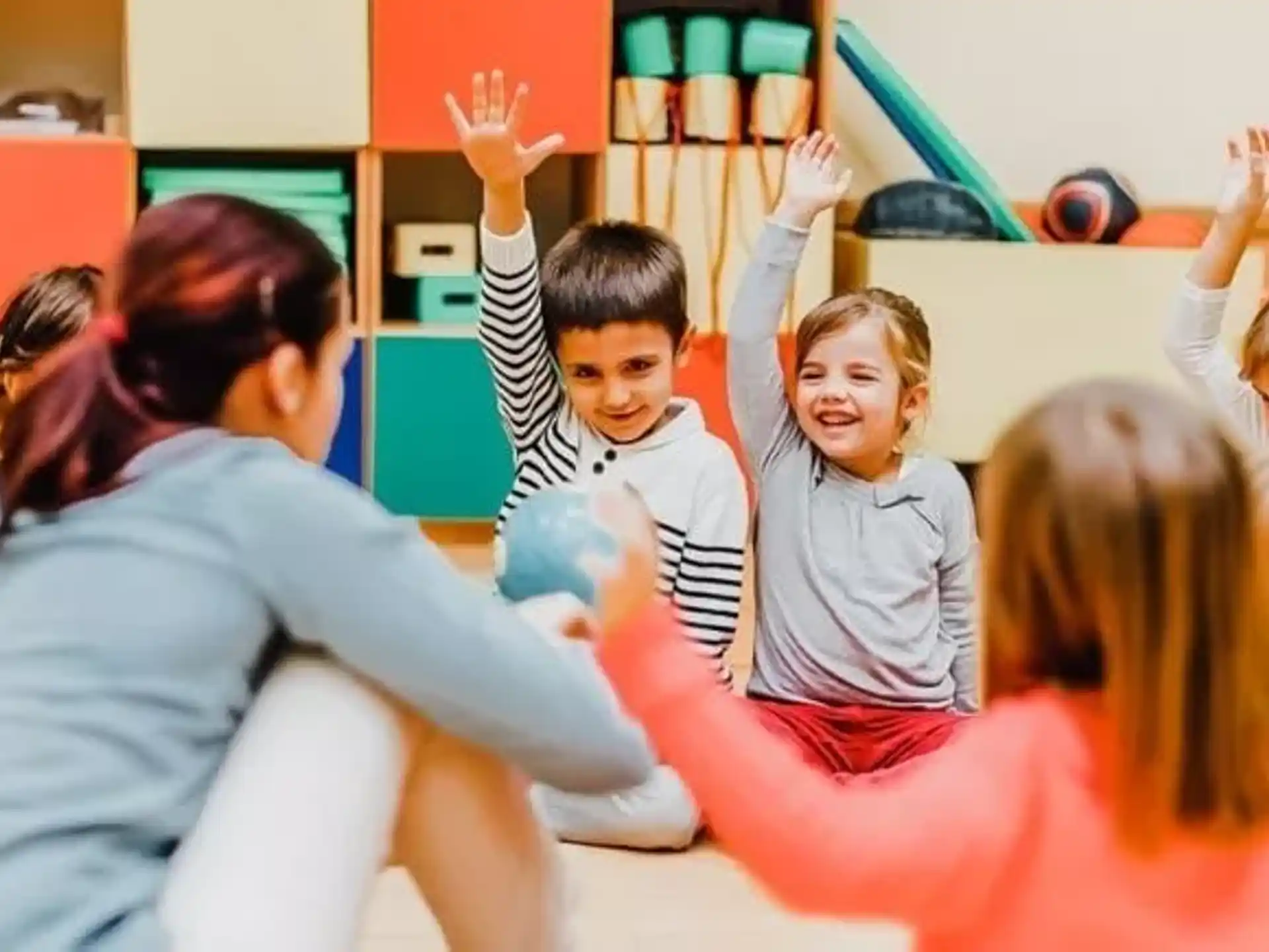 a group of children raising their hands