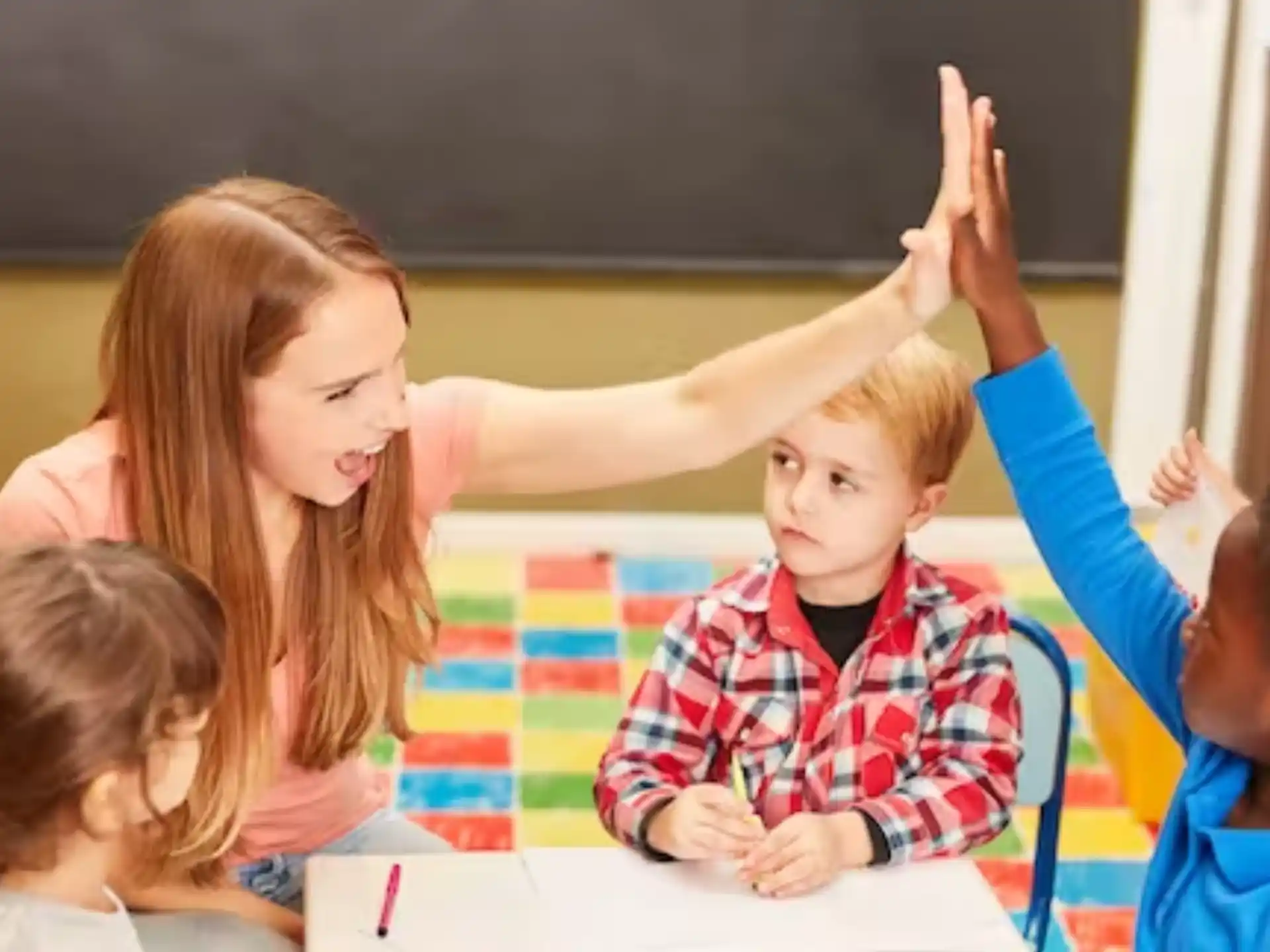 a group of children raising their hands