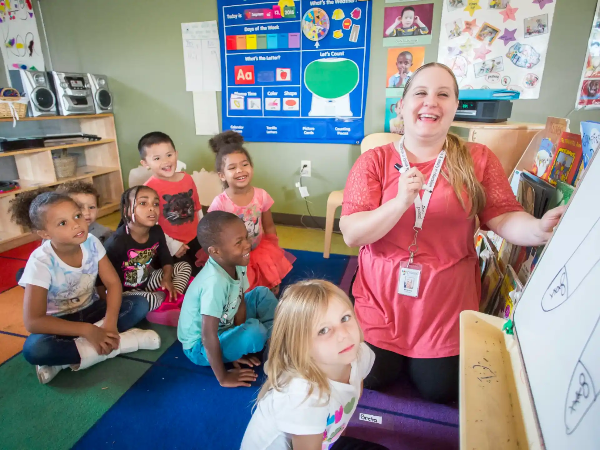 a person and a group of children in a classroom