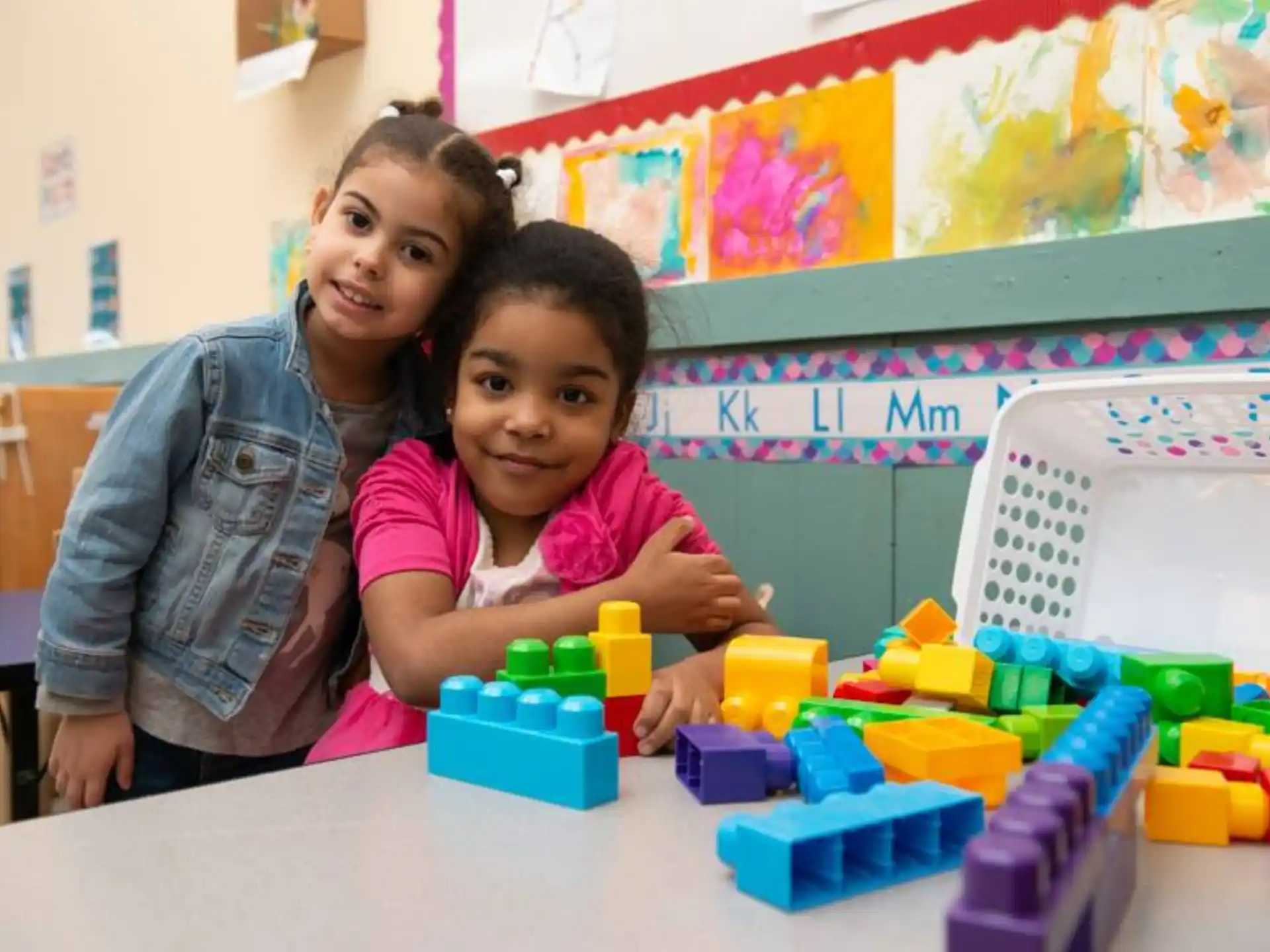 a person and a child playing with toys in a classroom