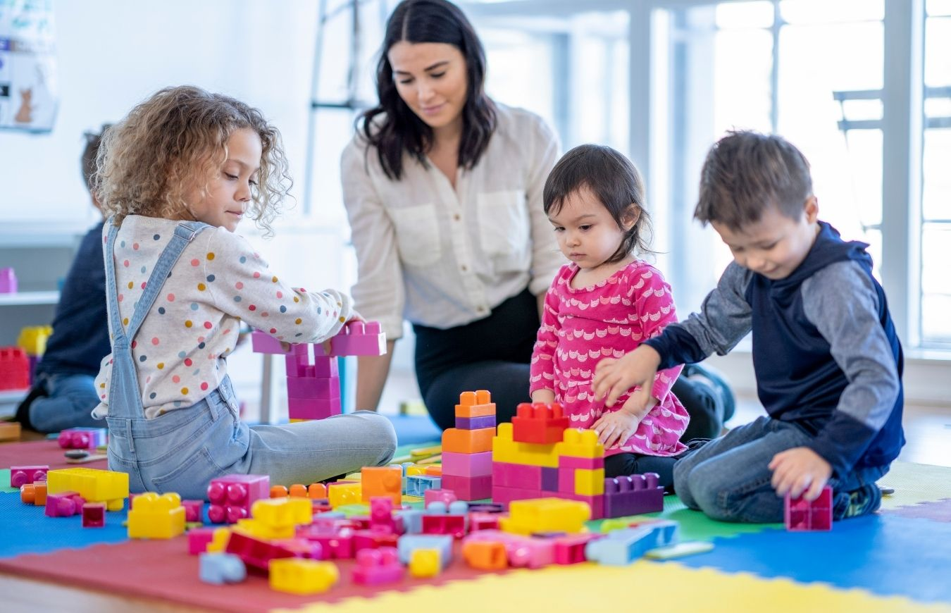 a group of people sitting on the floor with toys