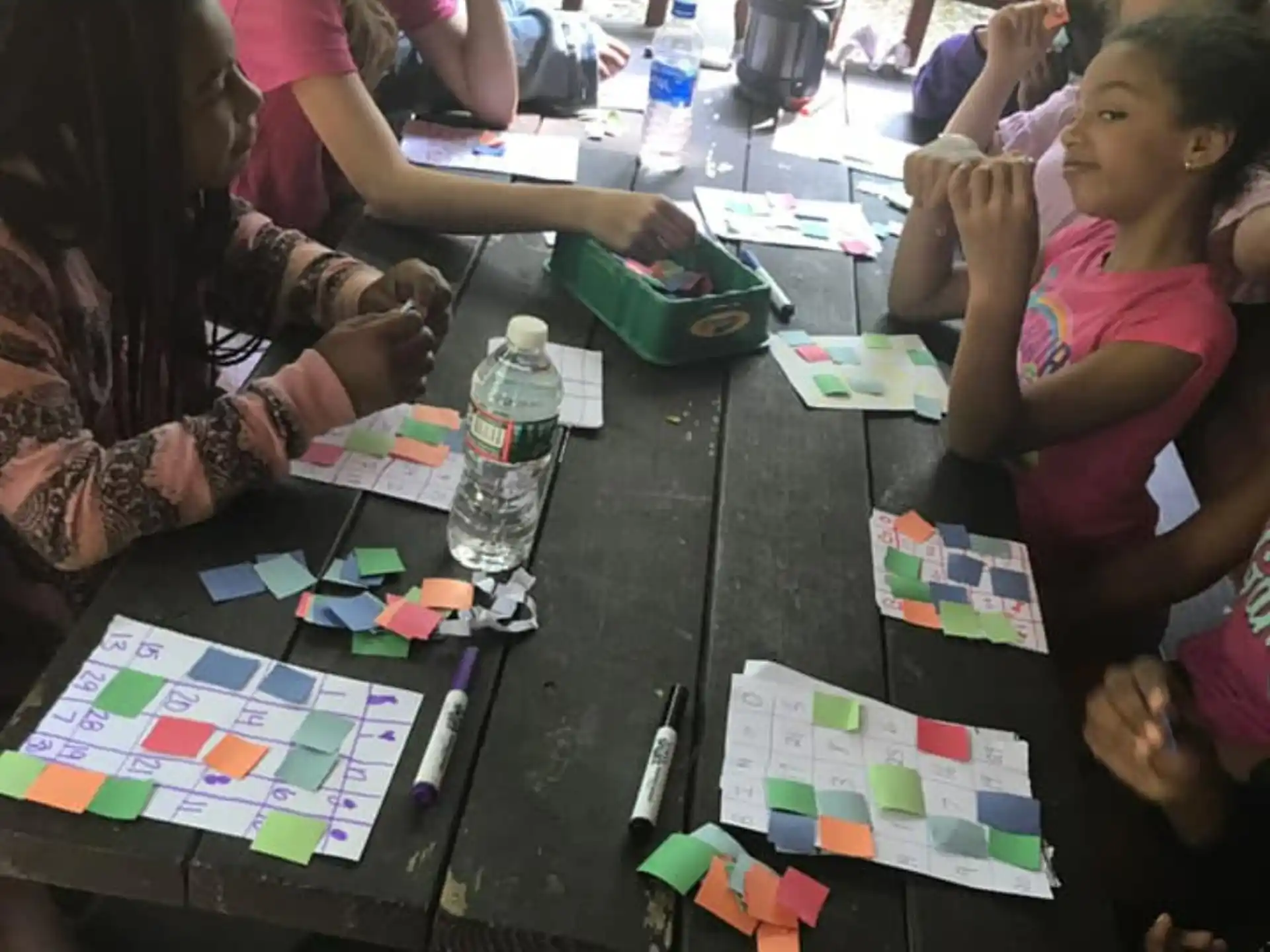 a group of children sitting around a table with cards on it