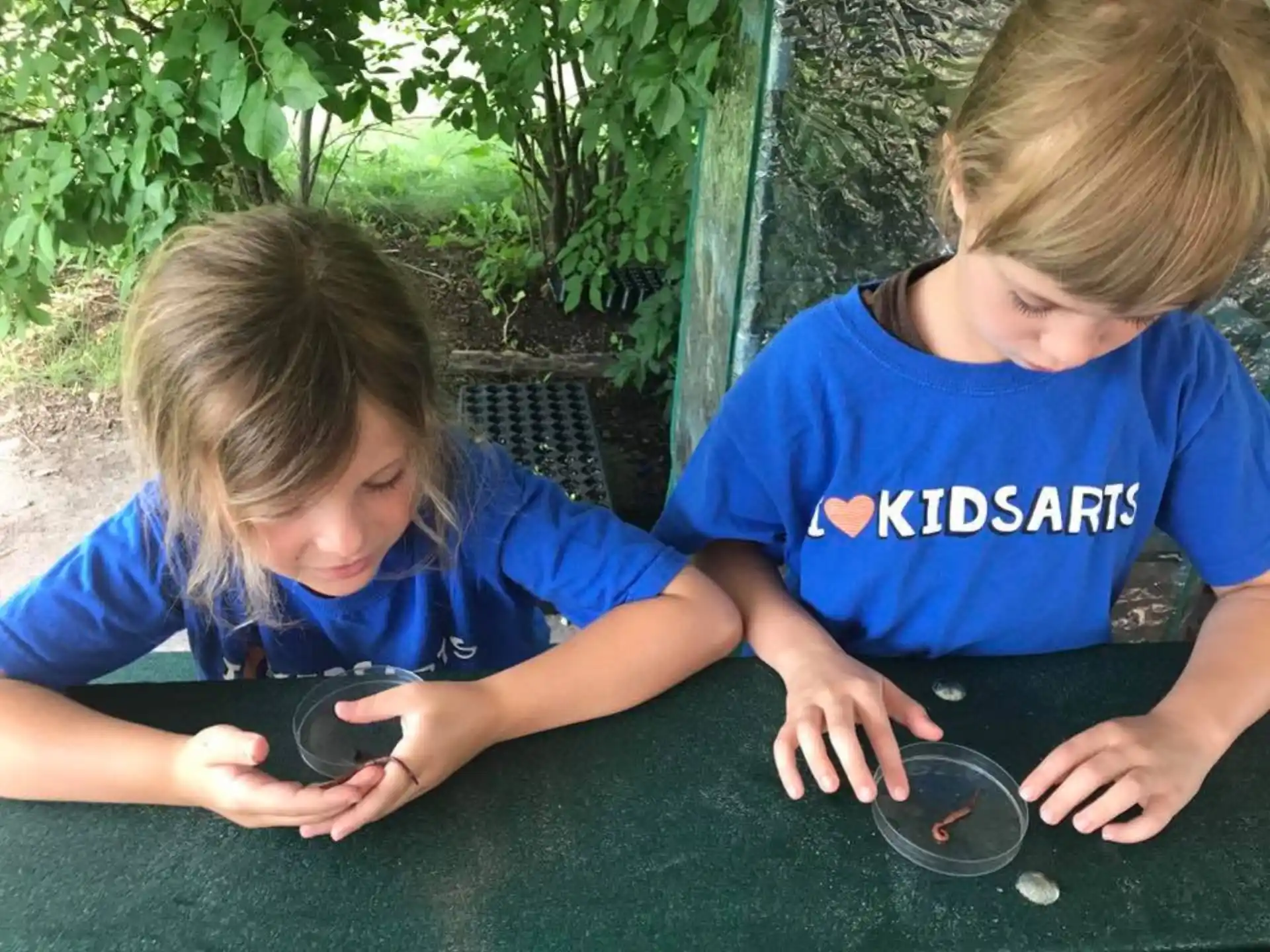 a couple of kids playing with a cell phone