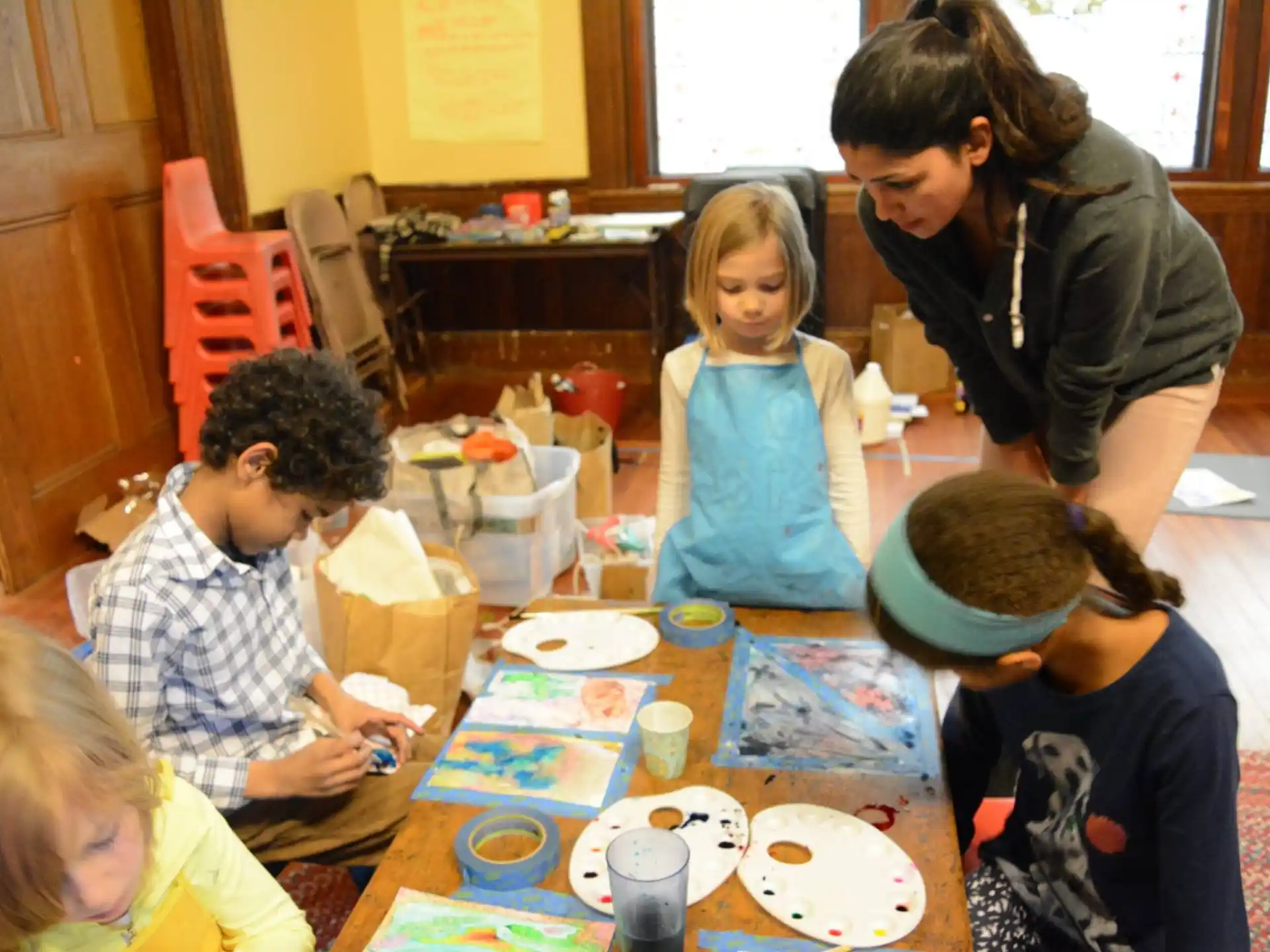a person and children sitting at a table with food