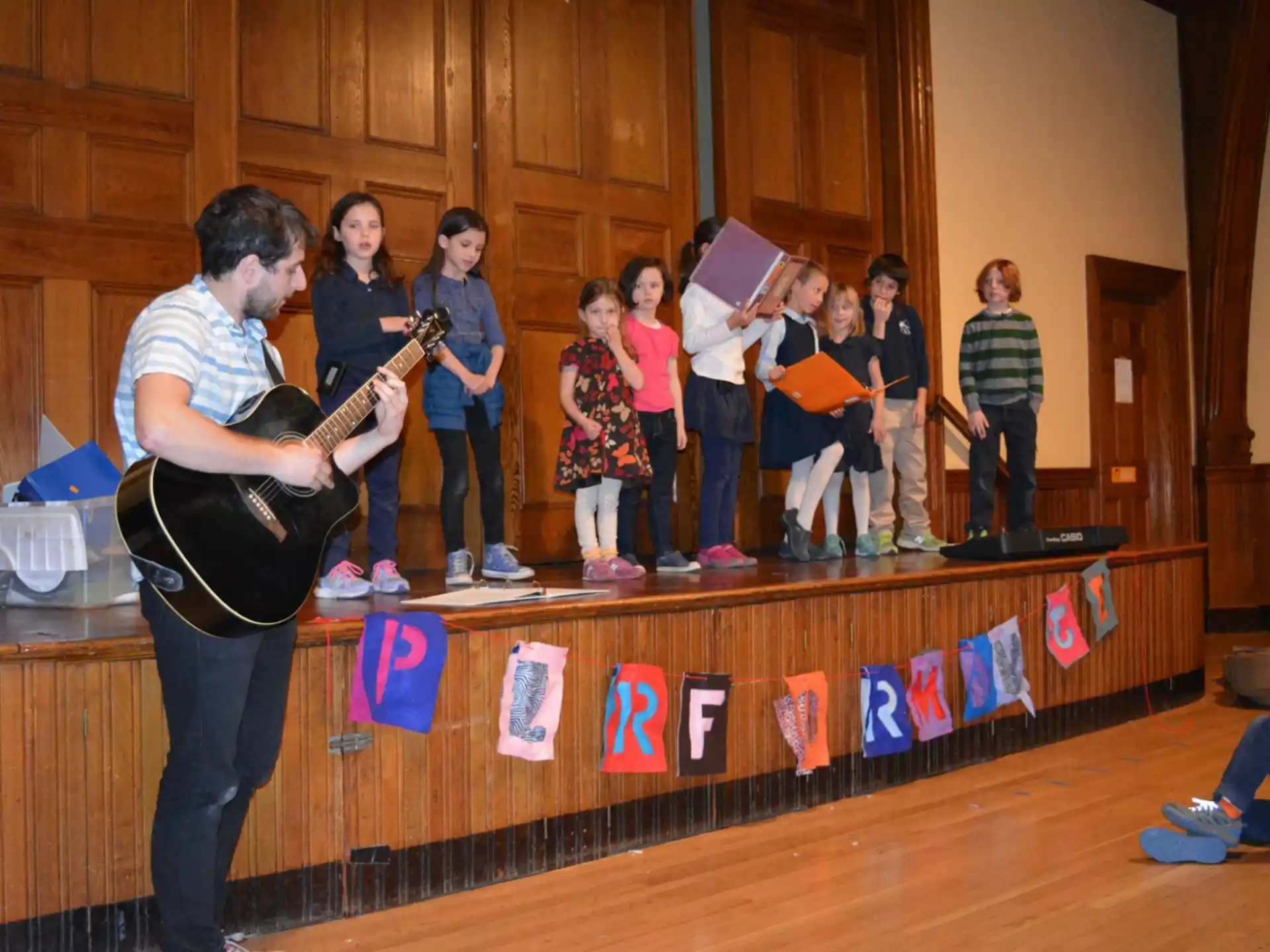 a person playing a guitar in front of a group of people