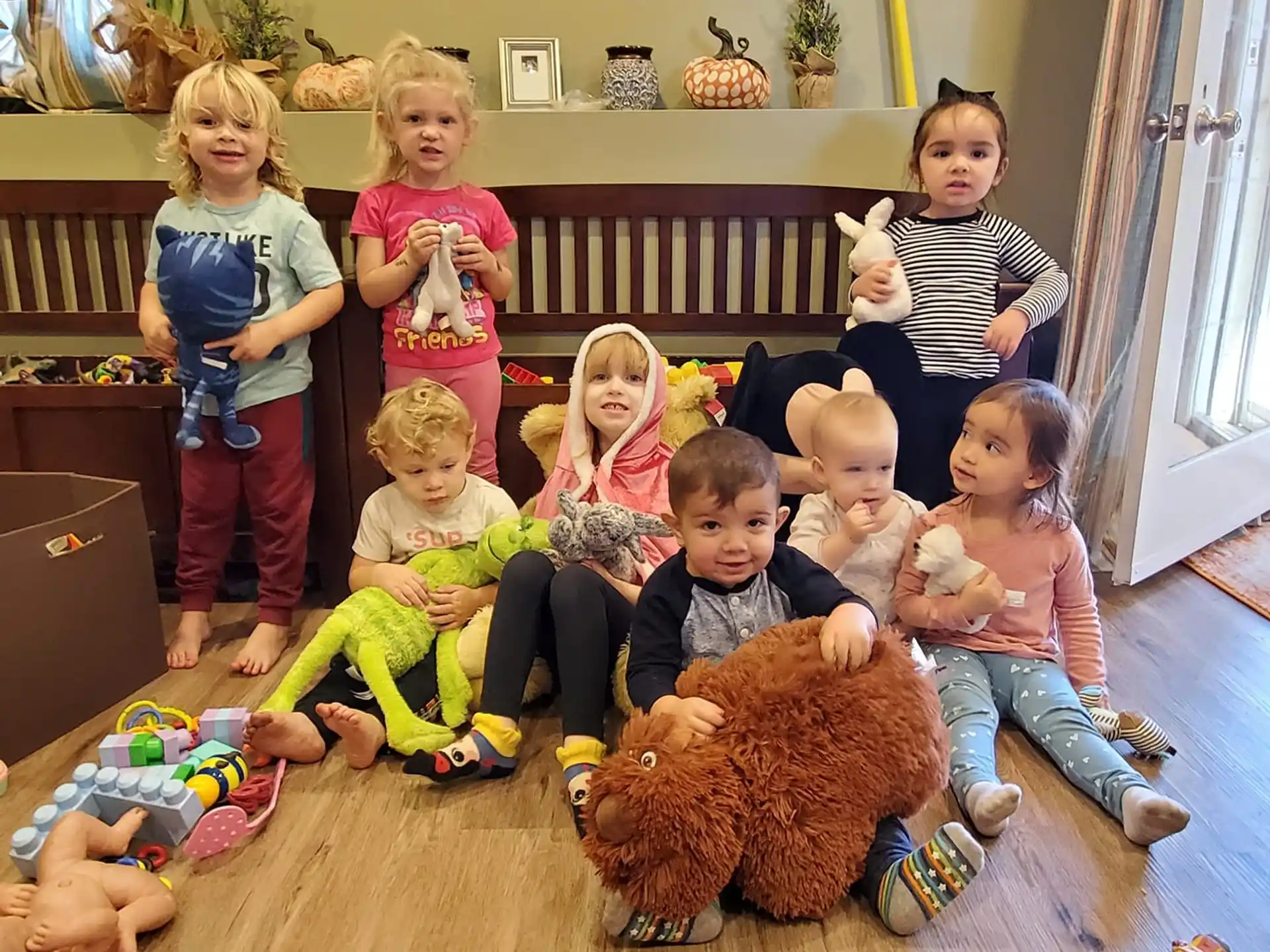 a group of children sitting on the floor with stuffed animals