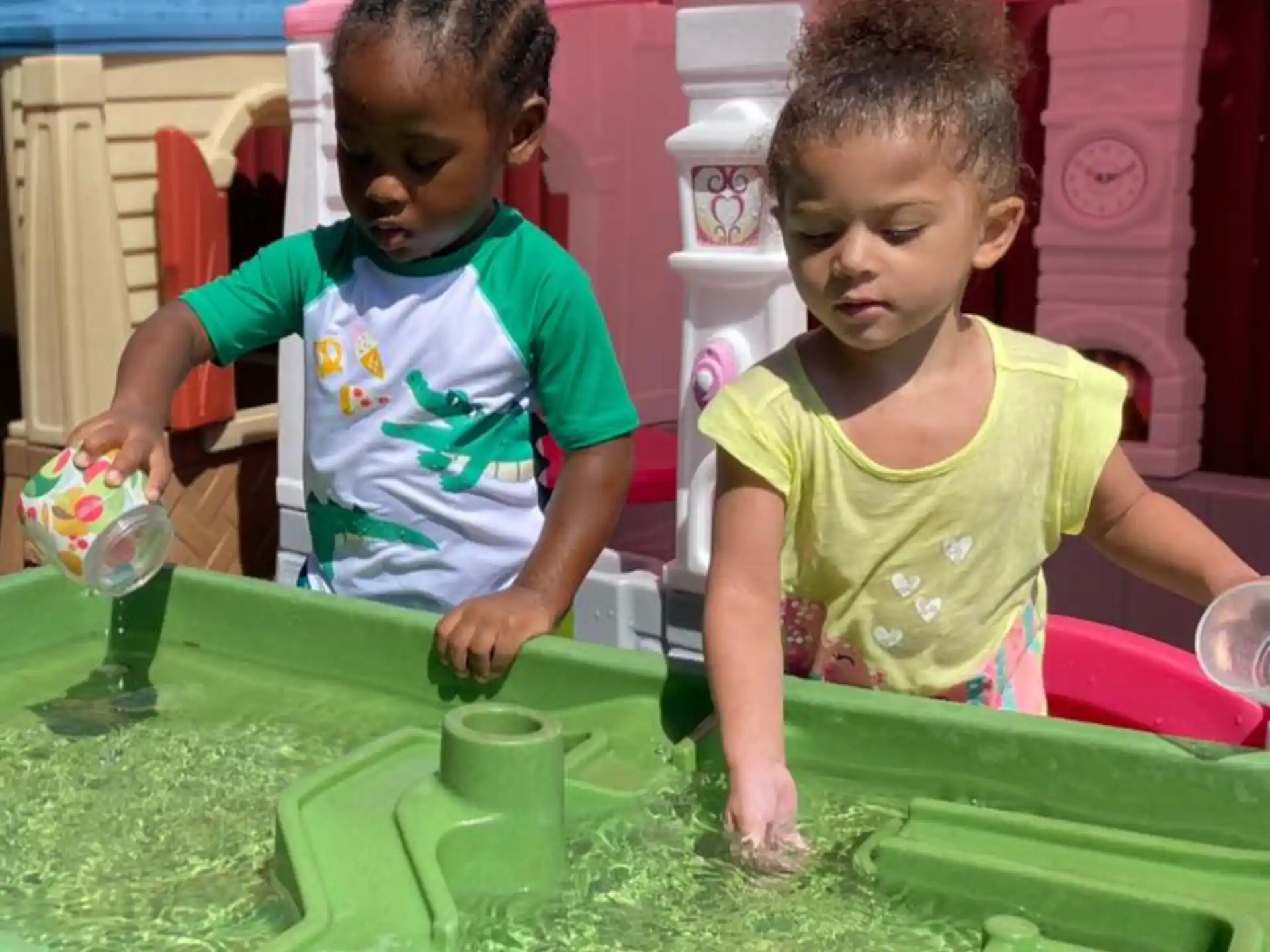 a couple of children playing in a water fountain