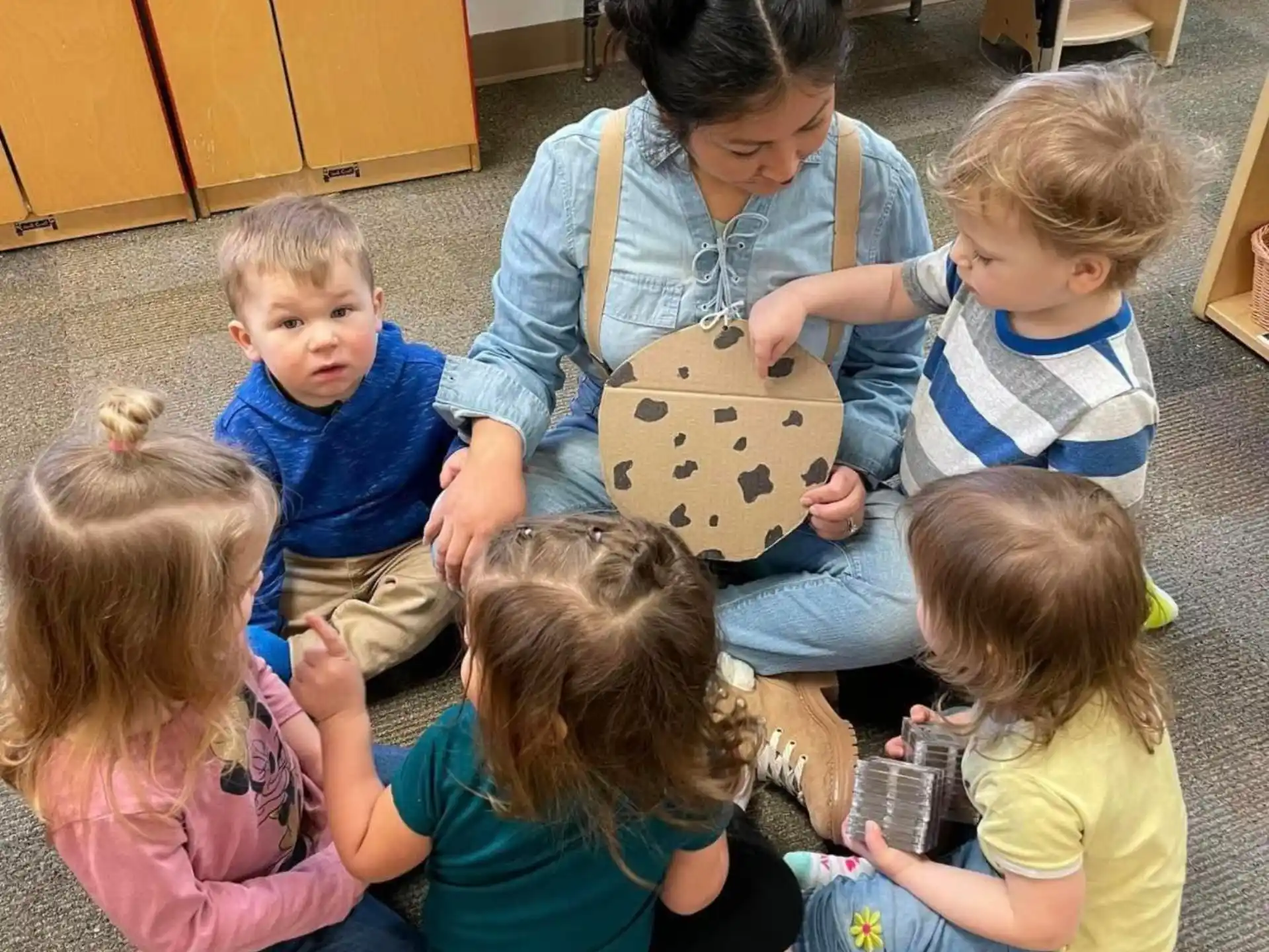 a person and several children sitting on the floor