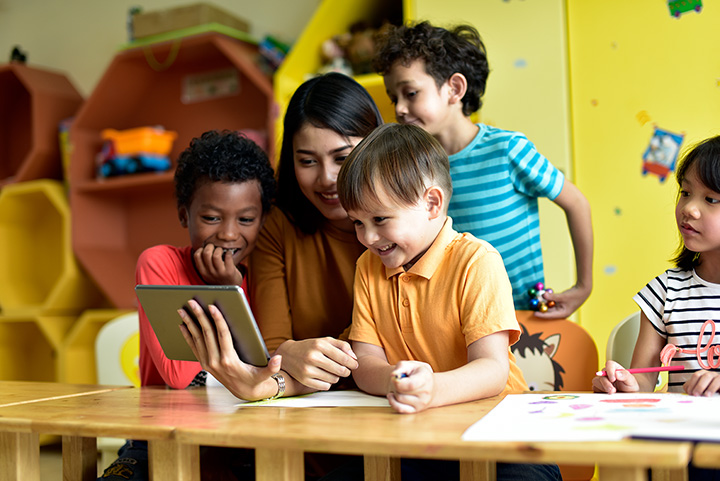 a group of children looking at a tablet