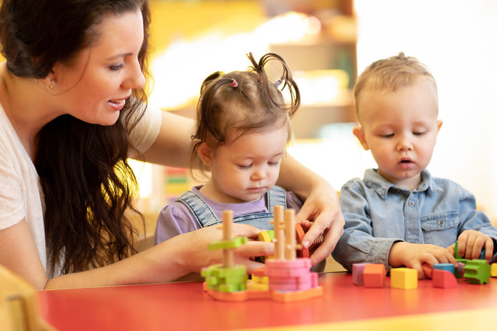 a person and two children playing with toys
