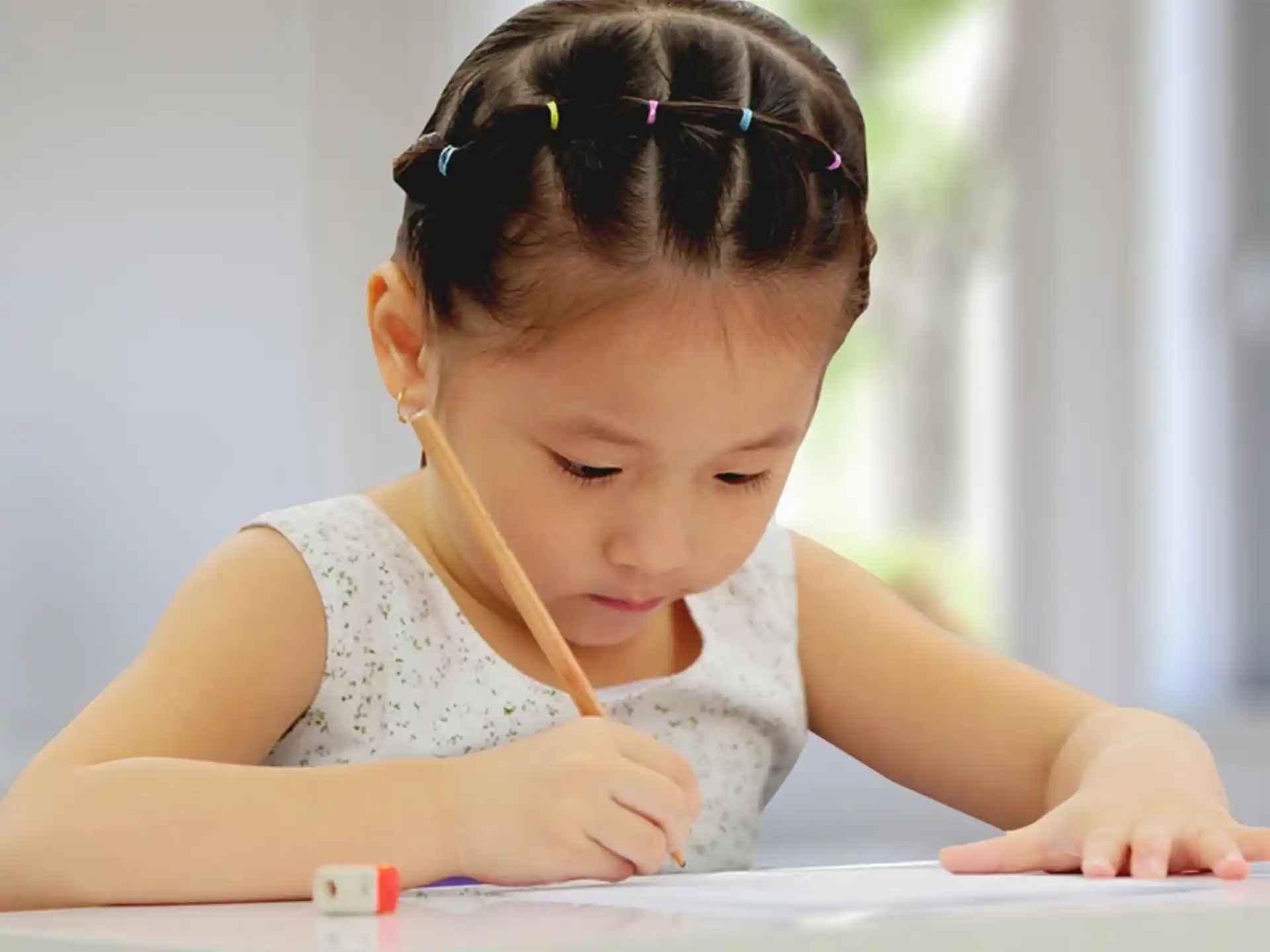 a young girl writing on a book