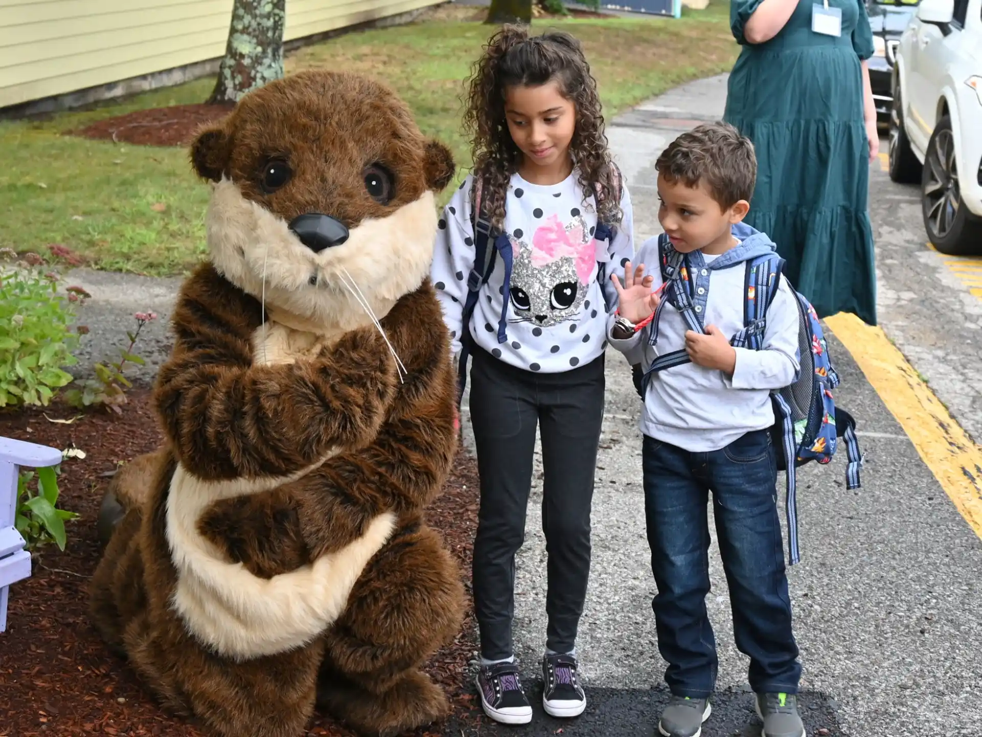 a person and a boy standing next to a person in a bear garment