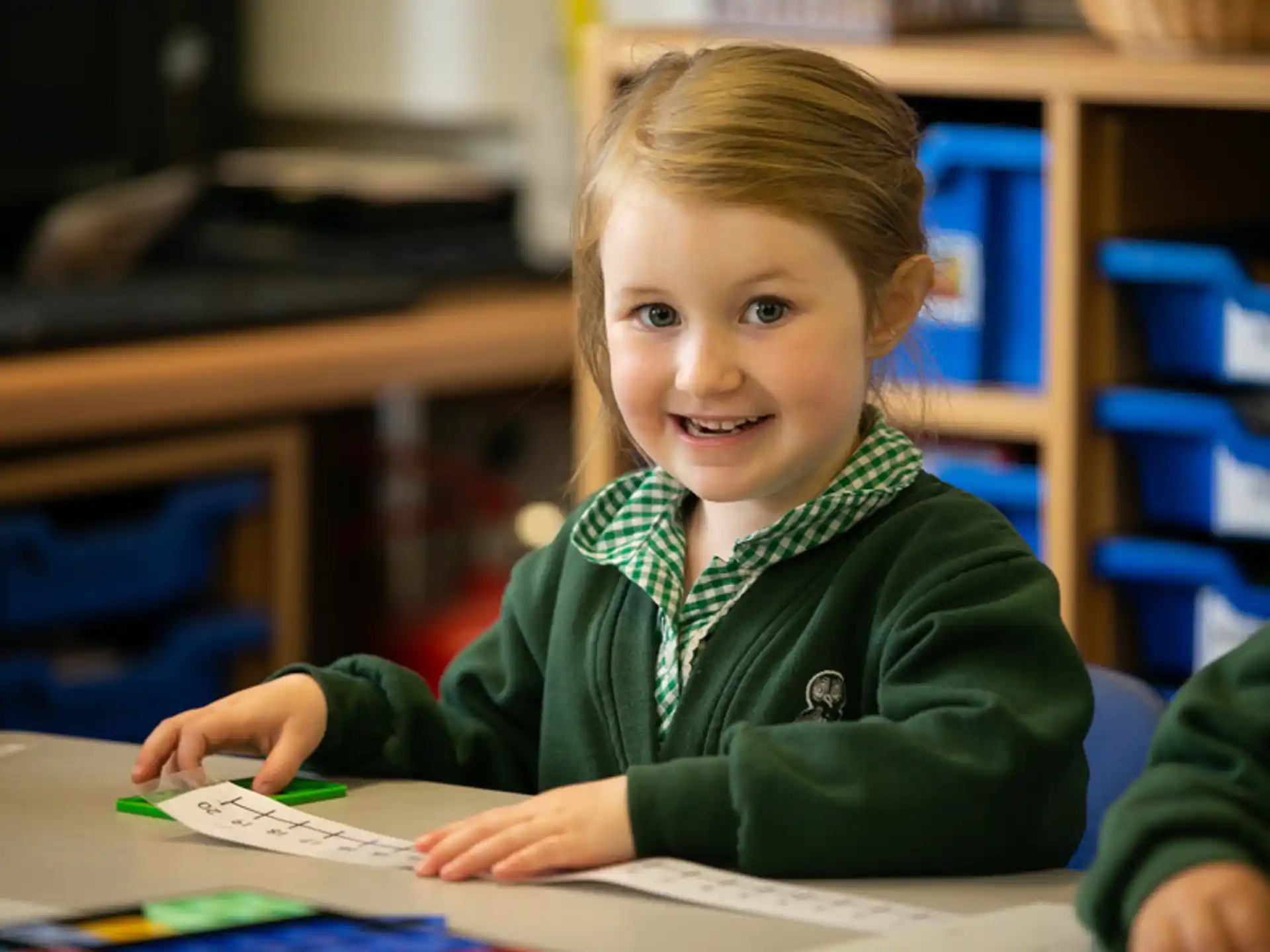 a young girl sitting at a desk