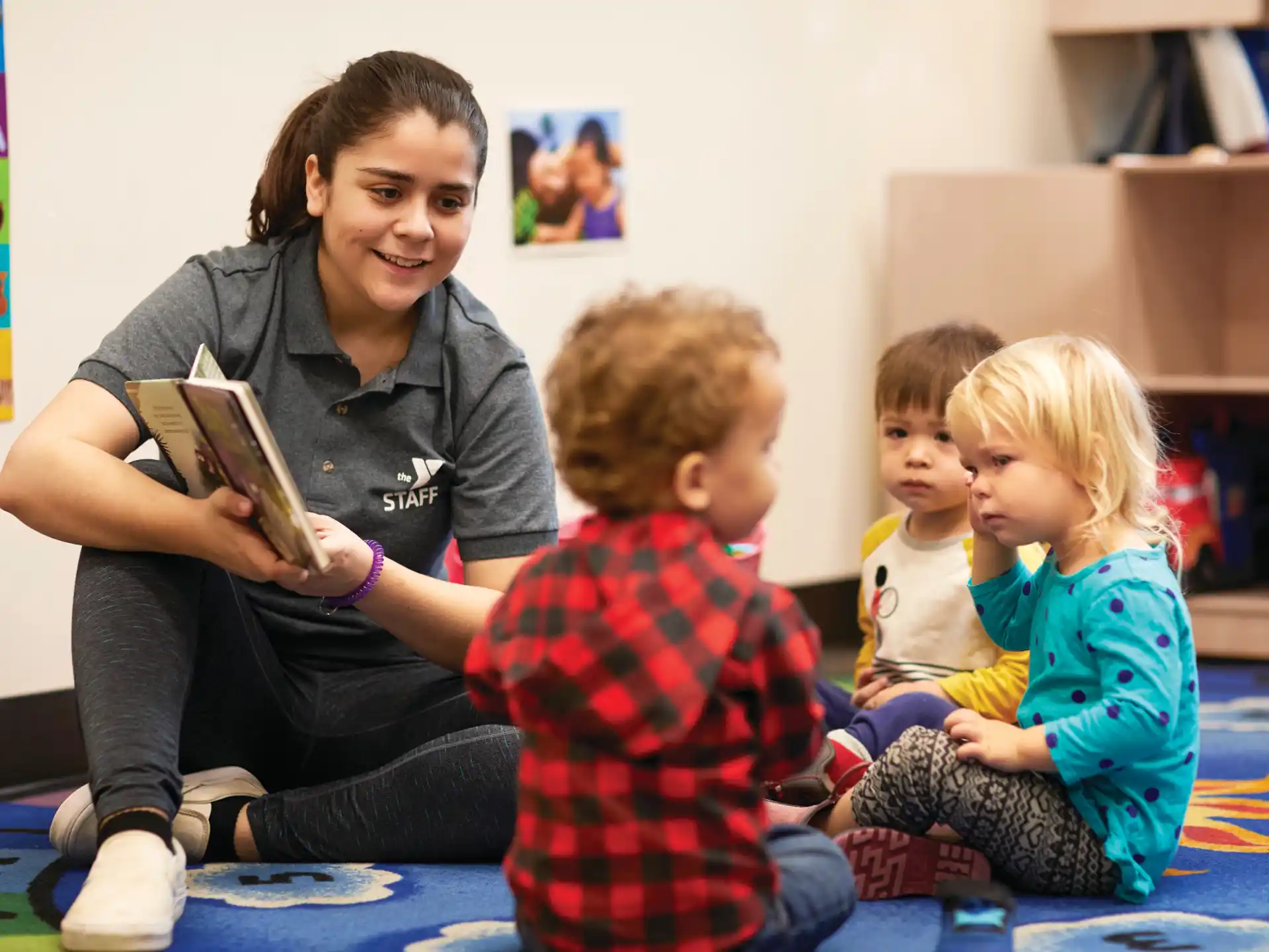 a person reading a book to a few children