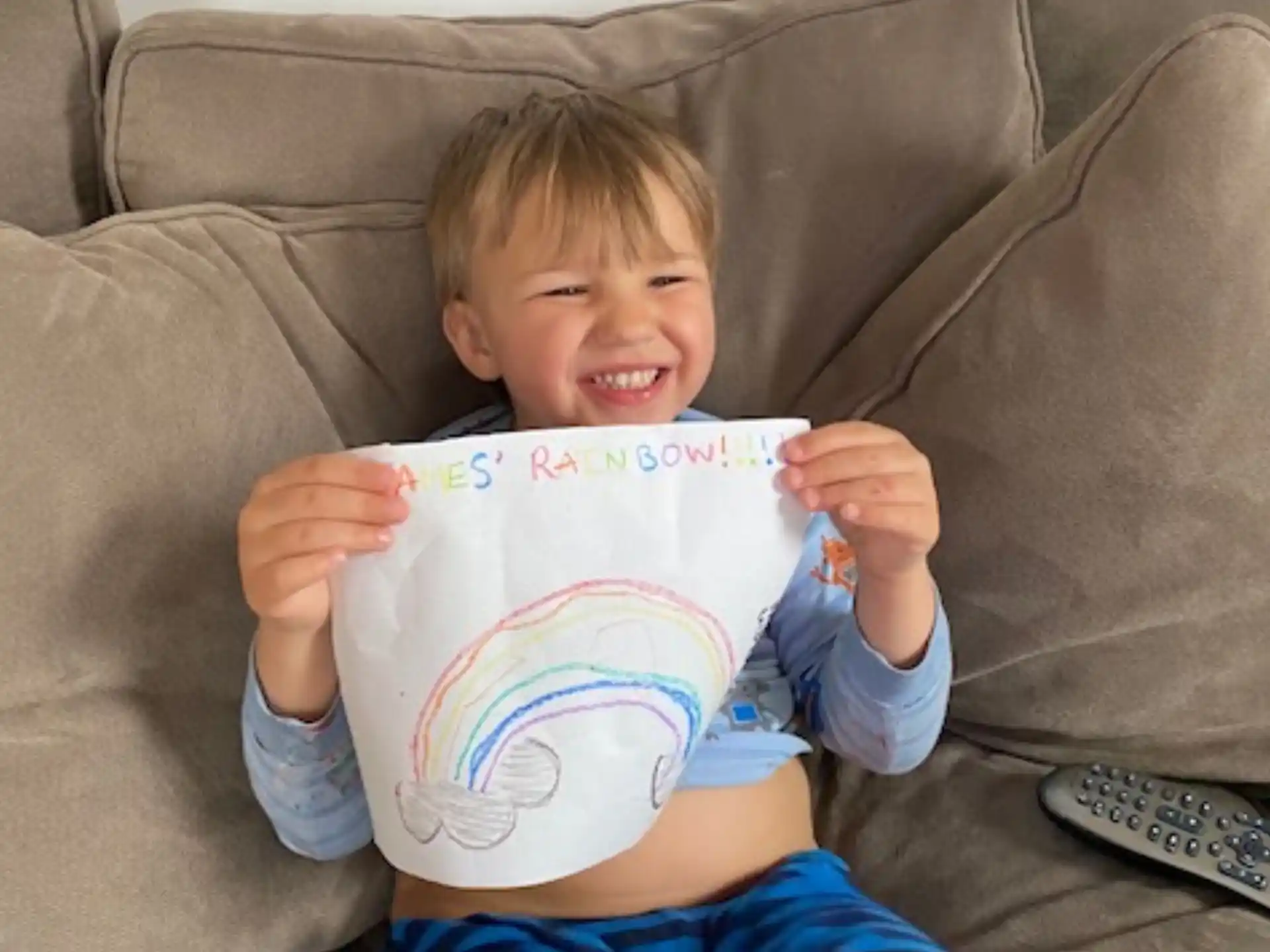 a boy sitting on a couch reading a book