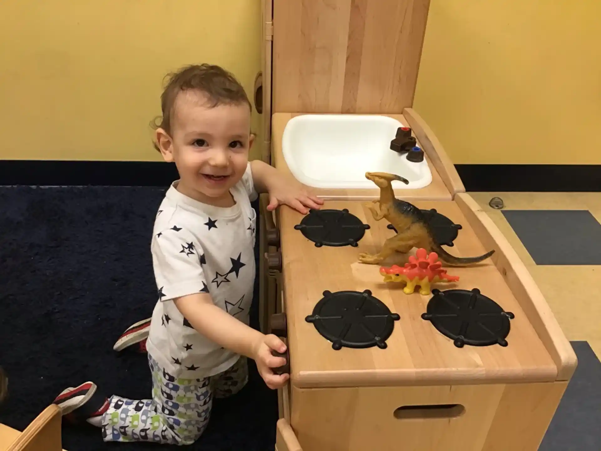 a boy standing next to a table with objects on it