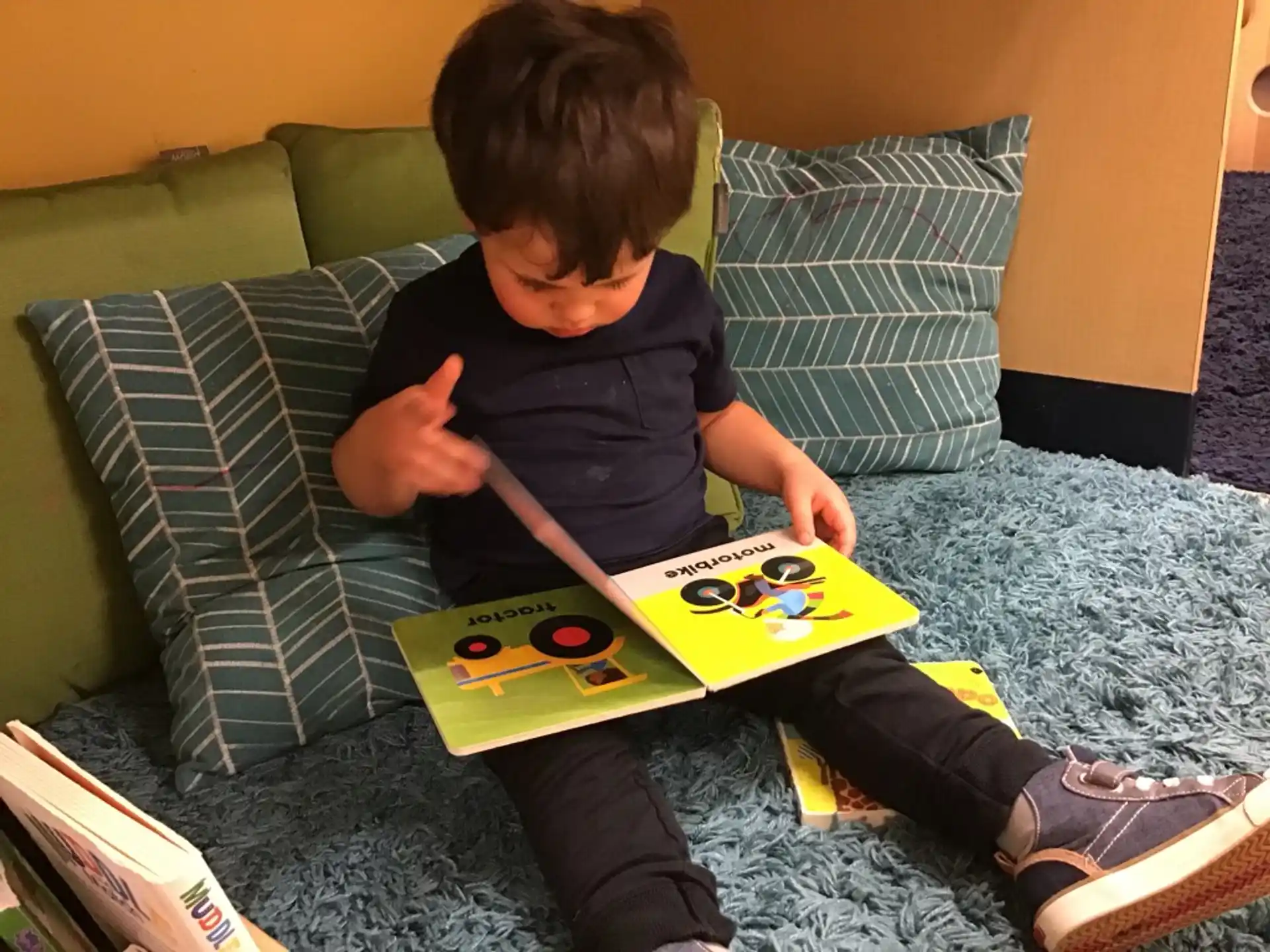 a boy sitting on the floor playing with a yellow and black toy