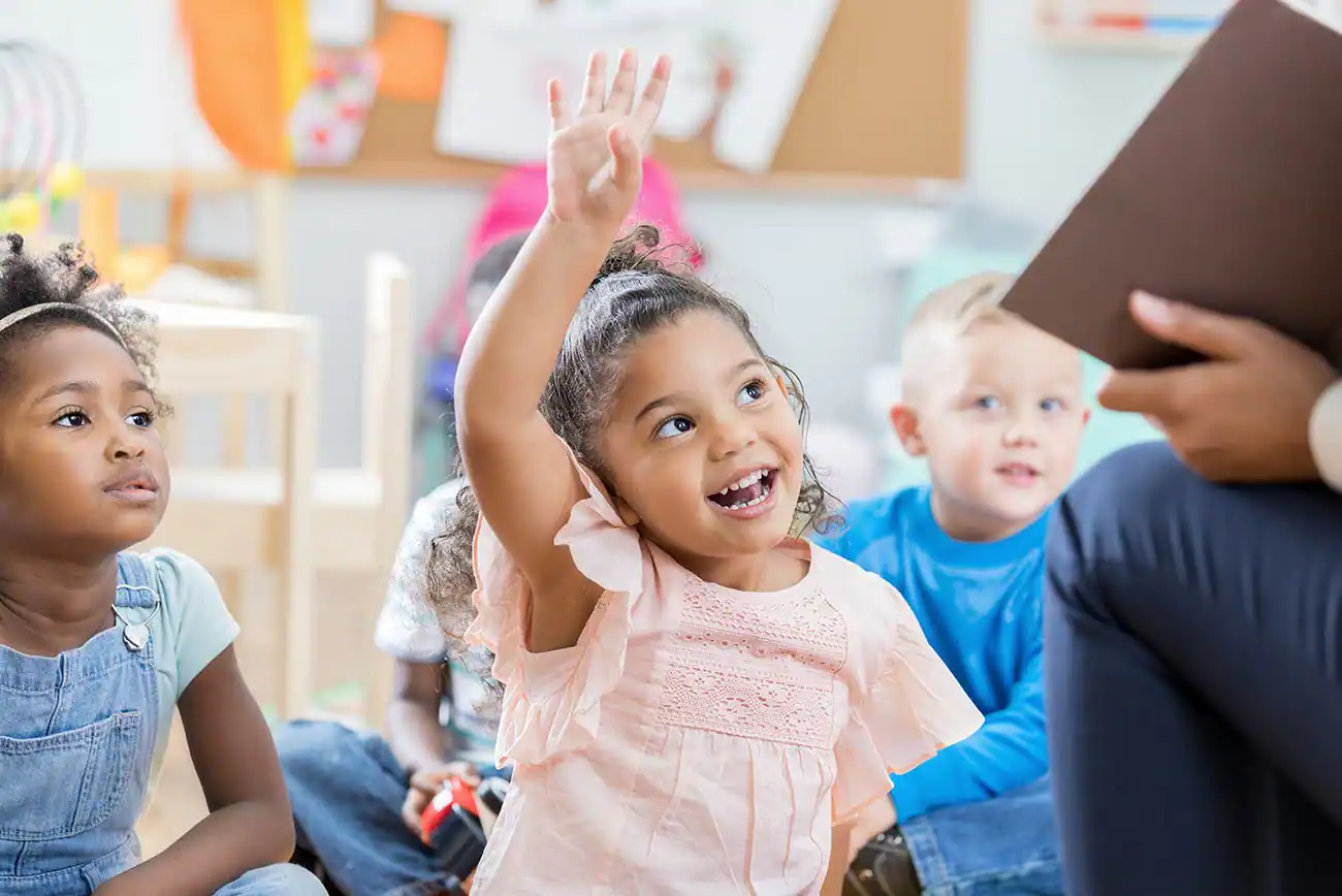 a group of children raising their hands