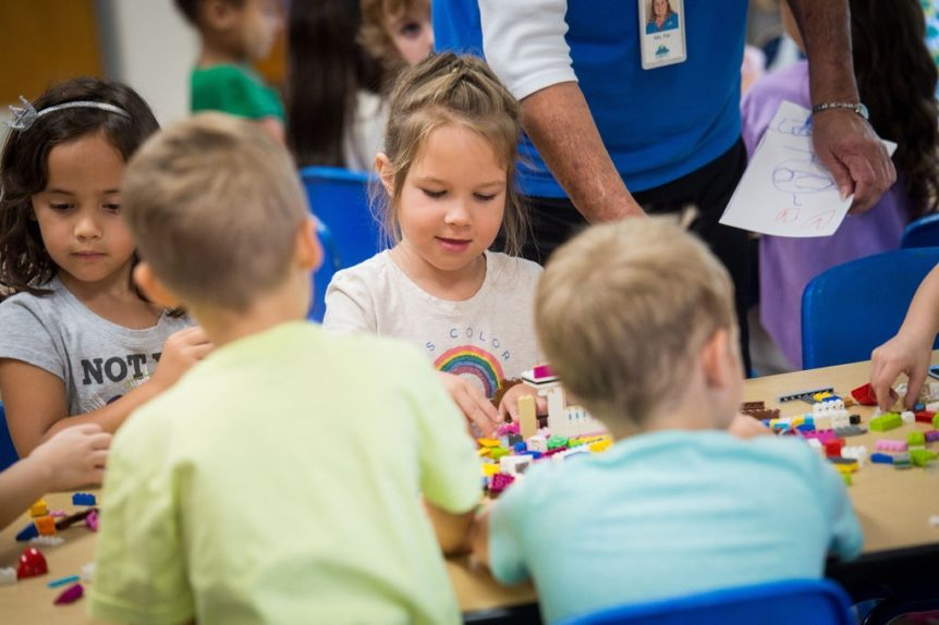 a group of children sitting at a table