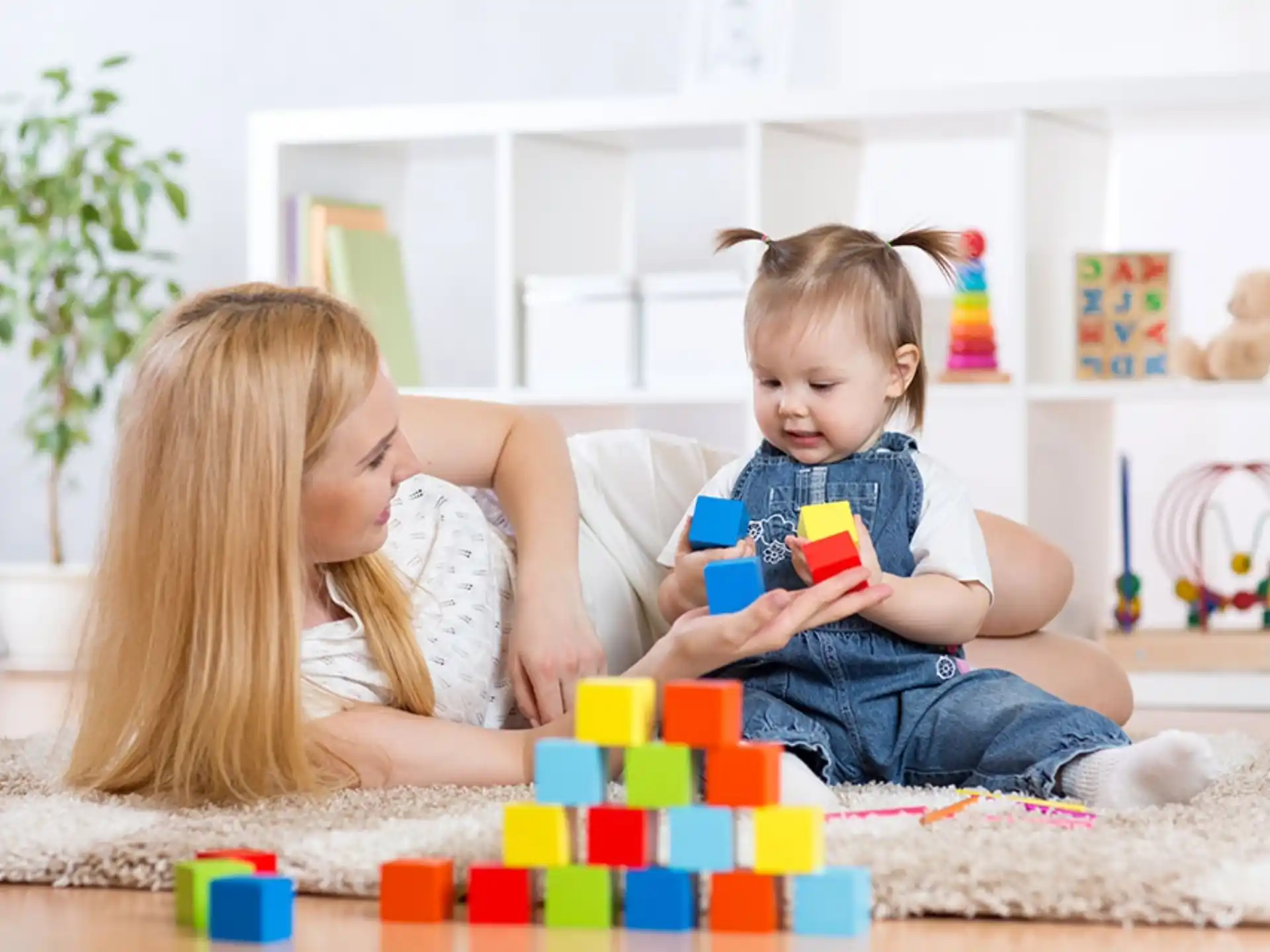 a person and a child playing with toys on the floor