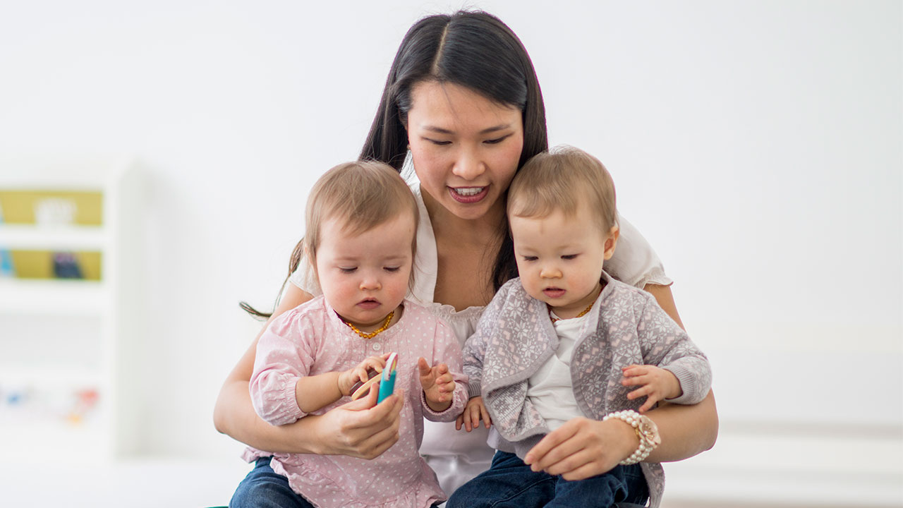a person holding two babies