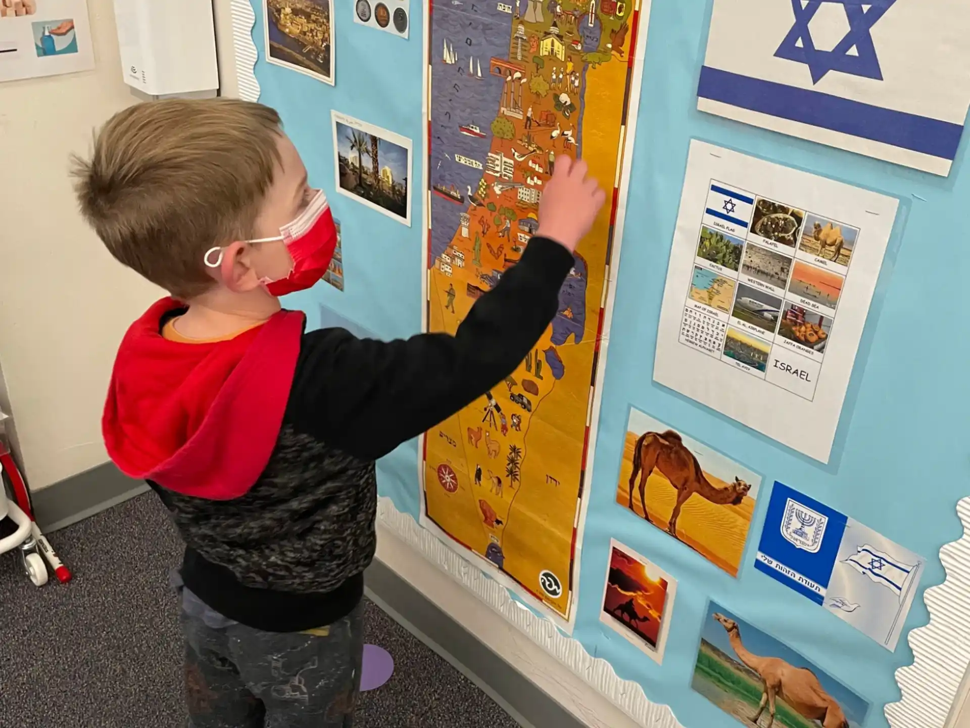a boy standing next to a poster