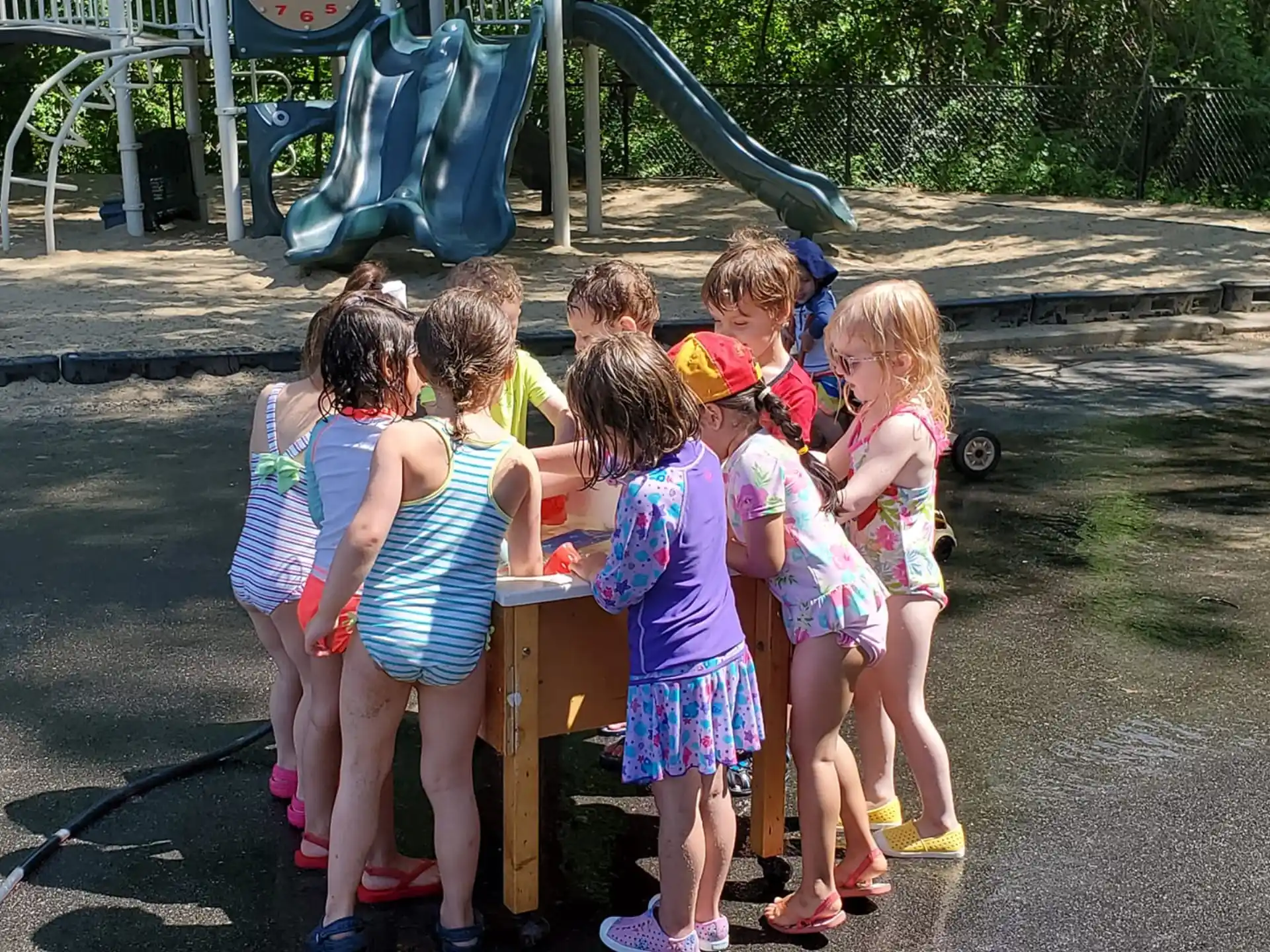 a group of children standing around a table outside