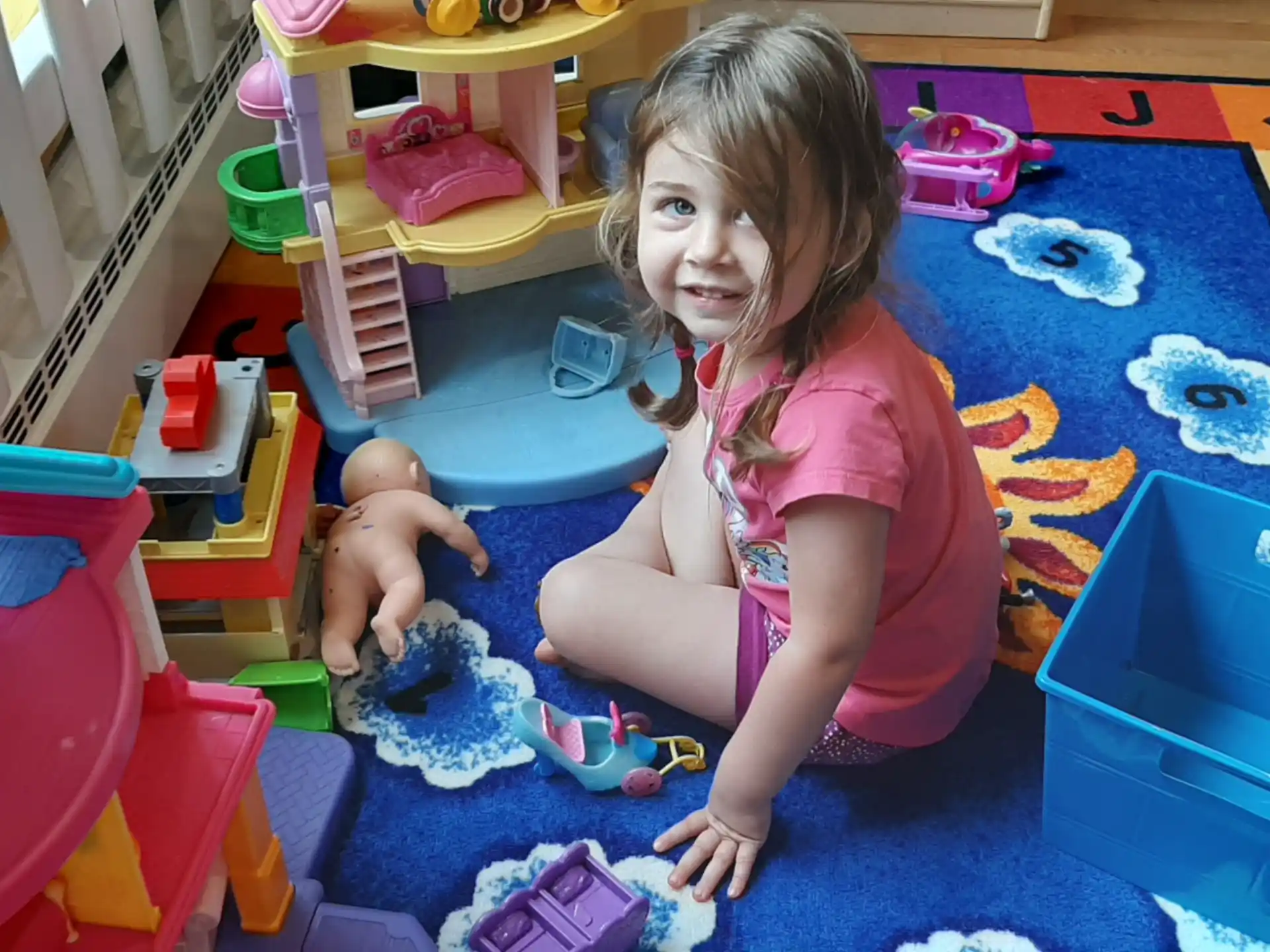 a girl and a baby playing on a blue and yellow play set
