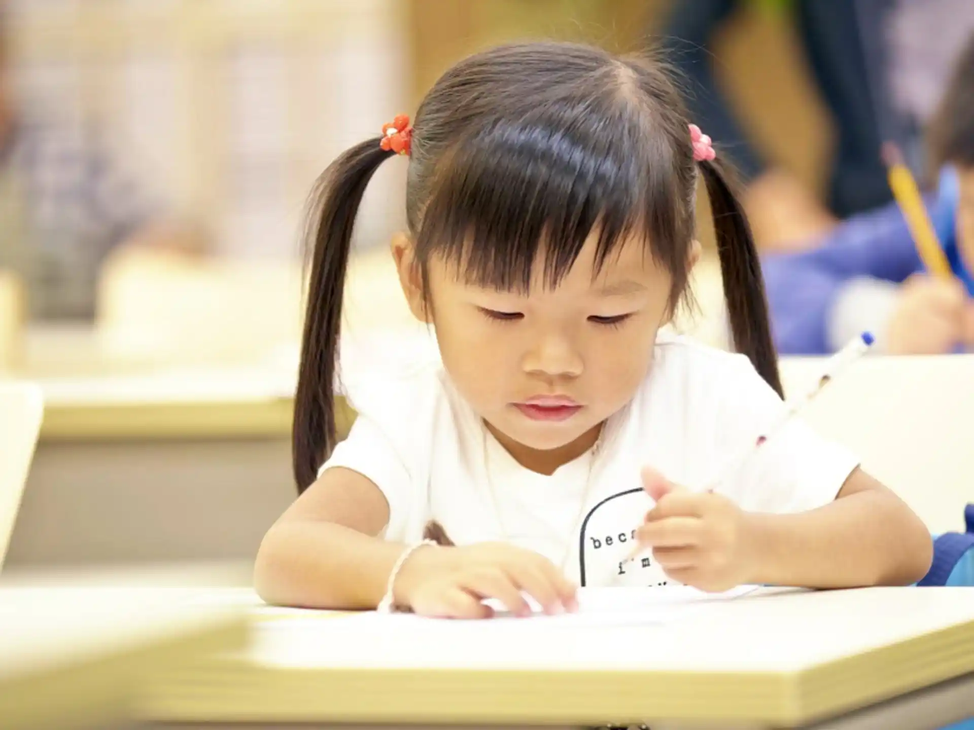 a young girl writing on a book