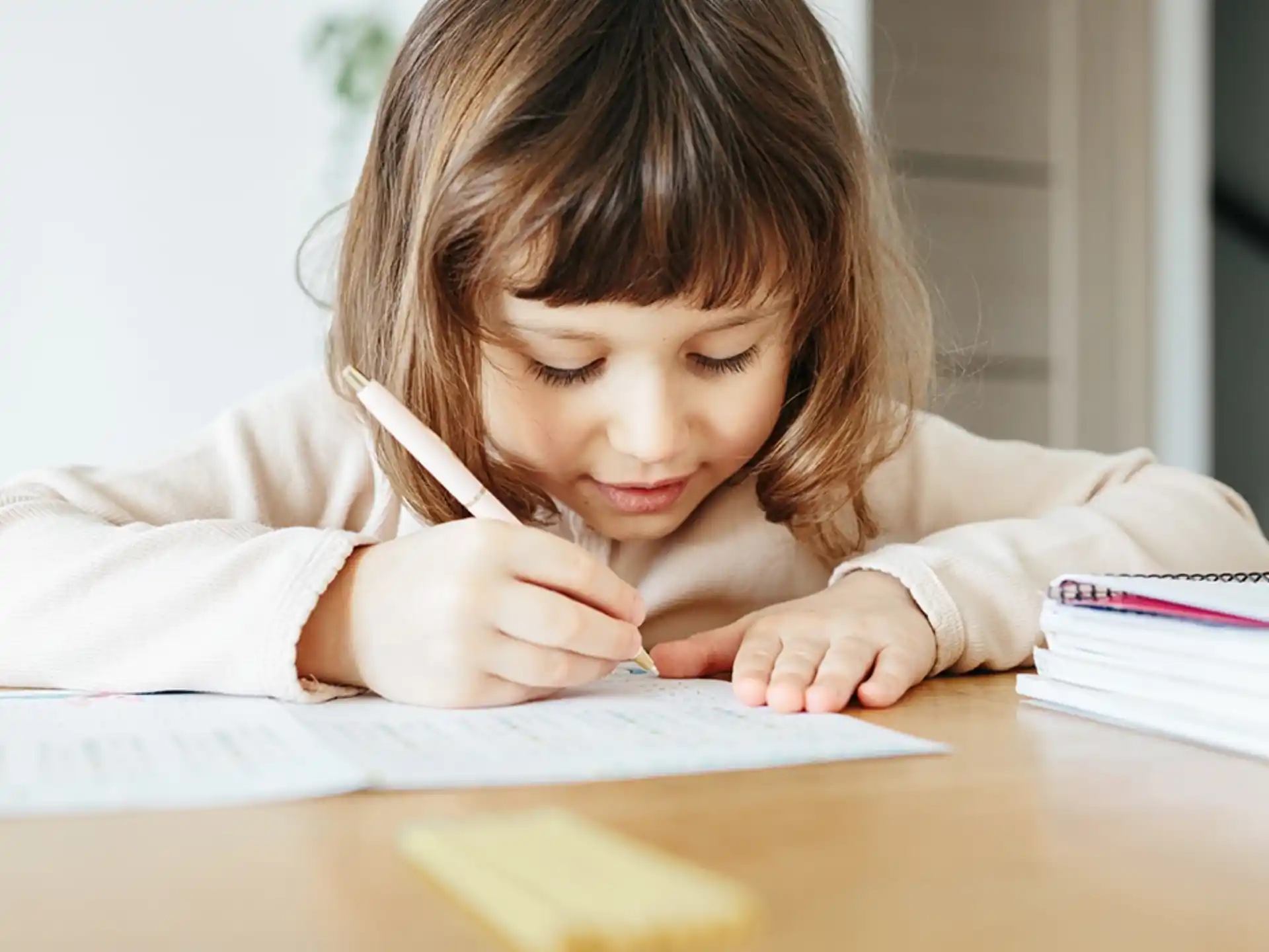 a young girl writing on a piece of paper