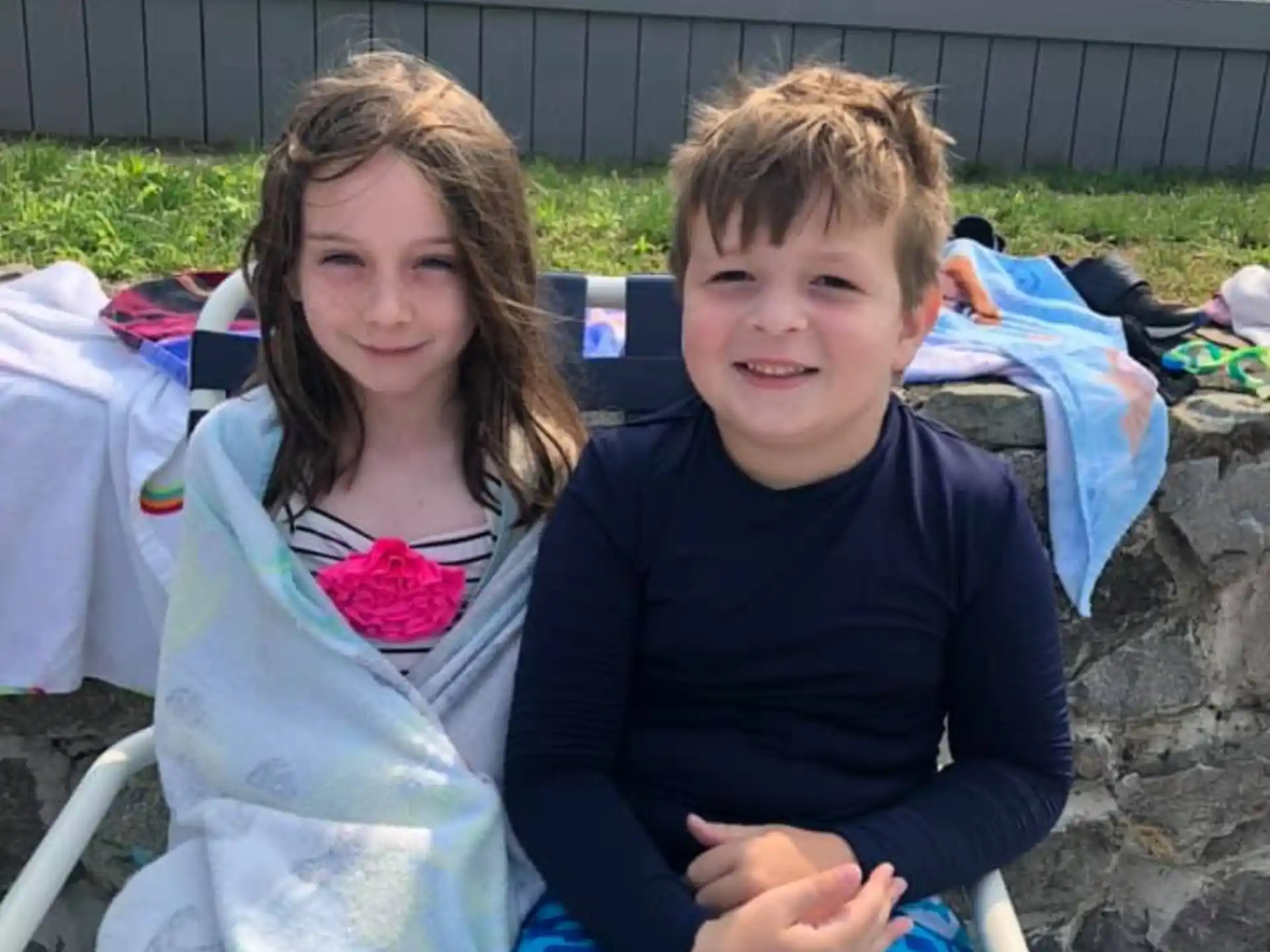 a boy and girl sitting on a bench