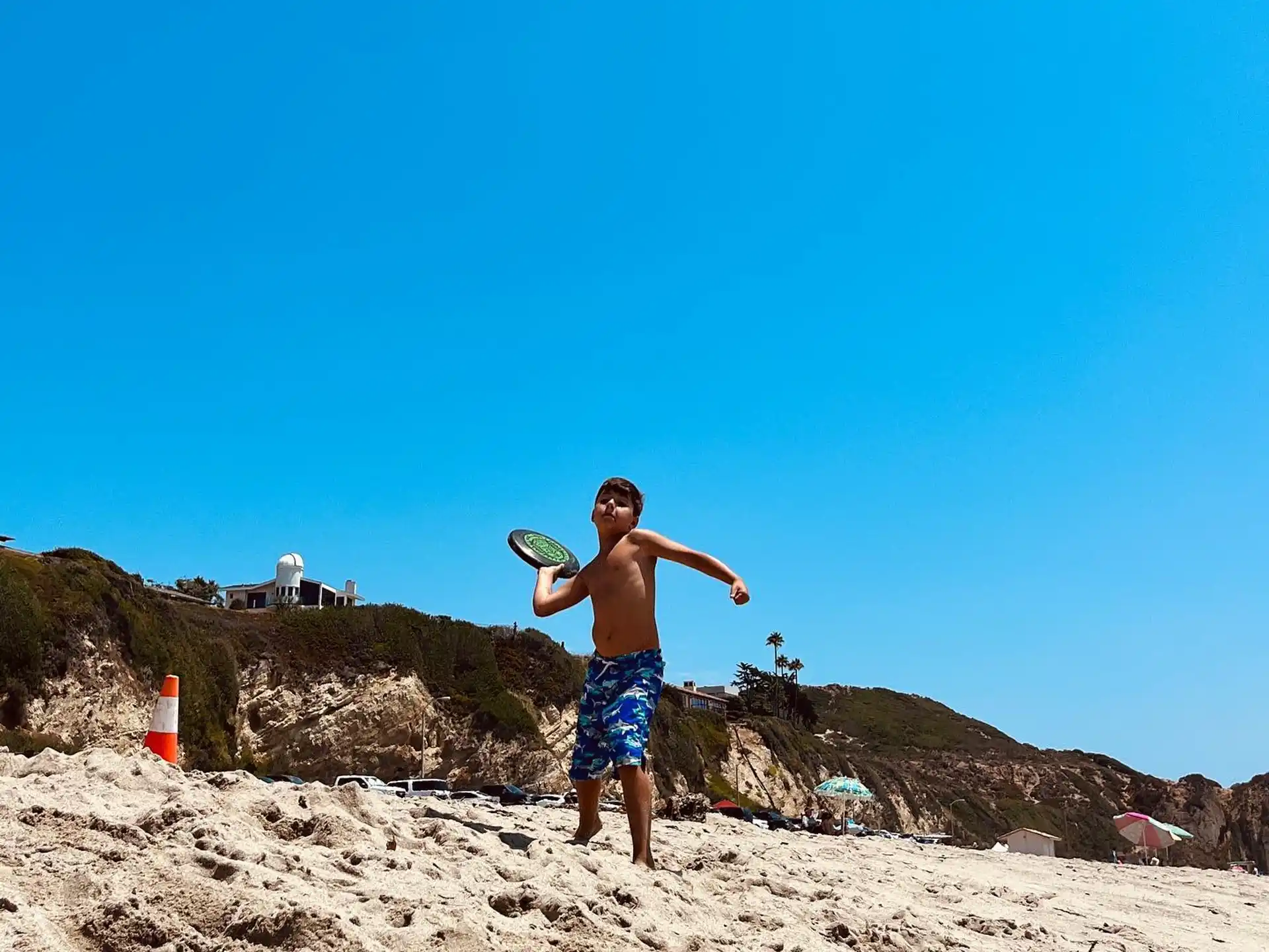 a man playing frisbee on the beach