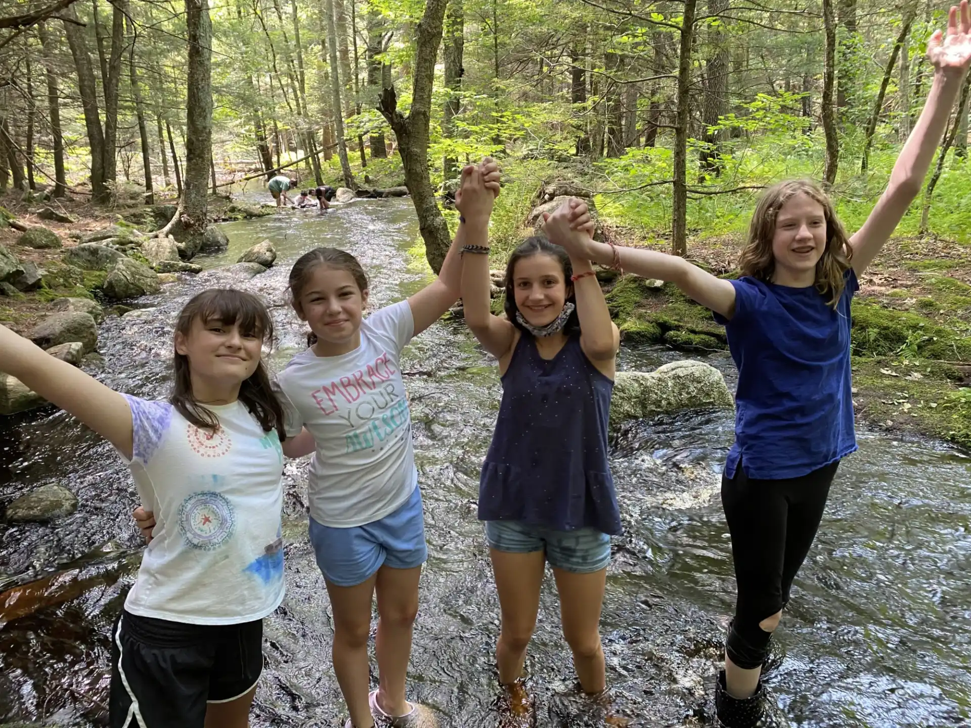 a group of girls posing for a picture in the woods