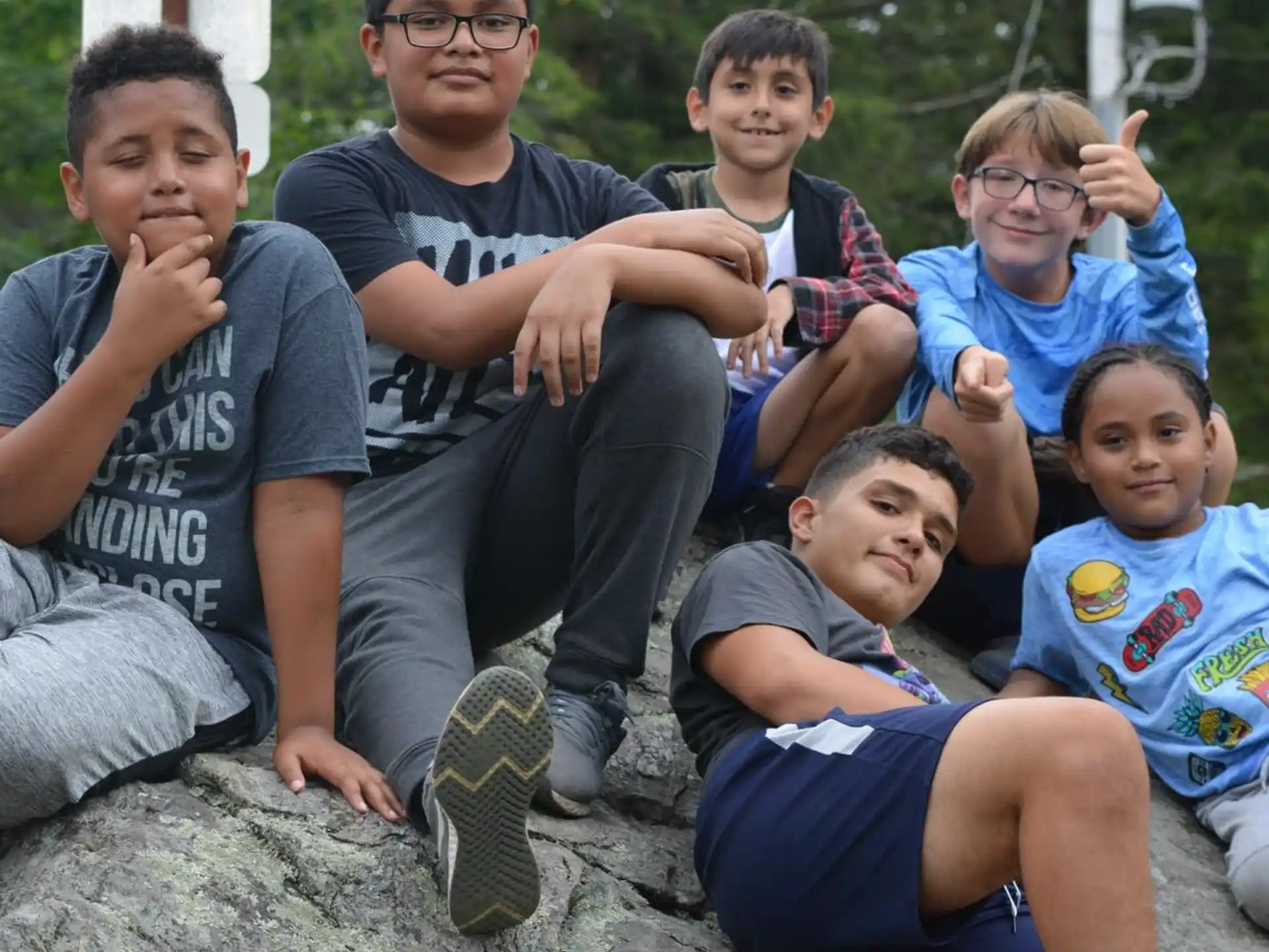 a group of boys sitting on a rock