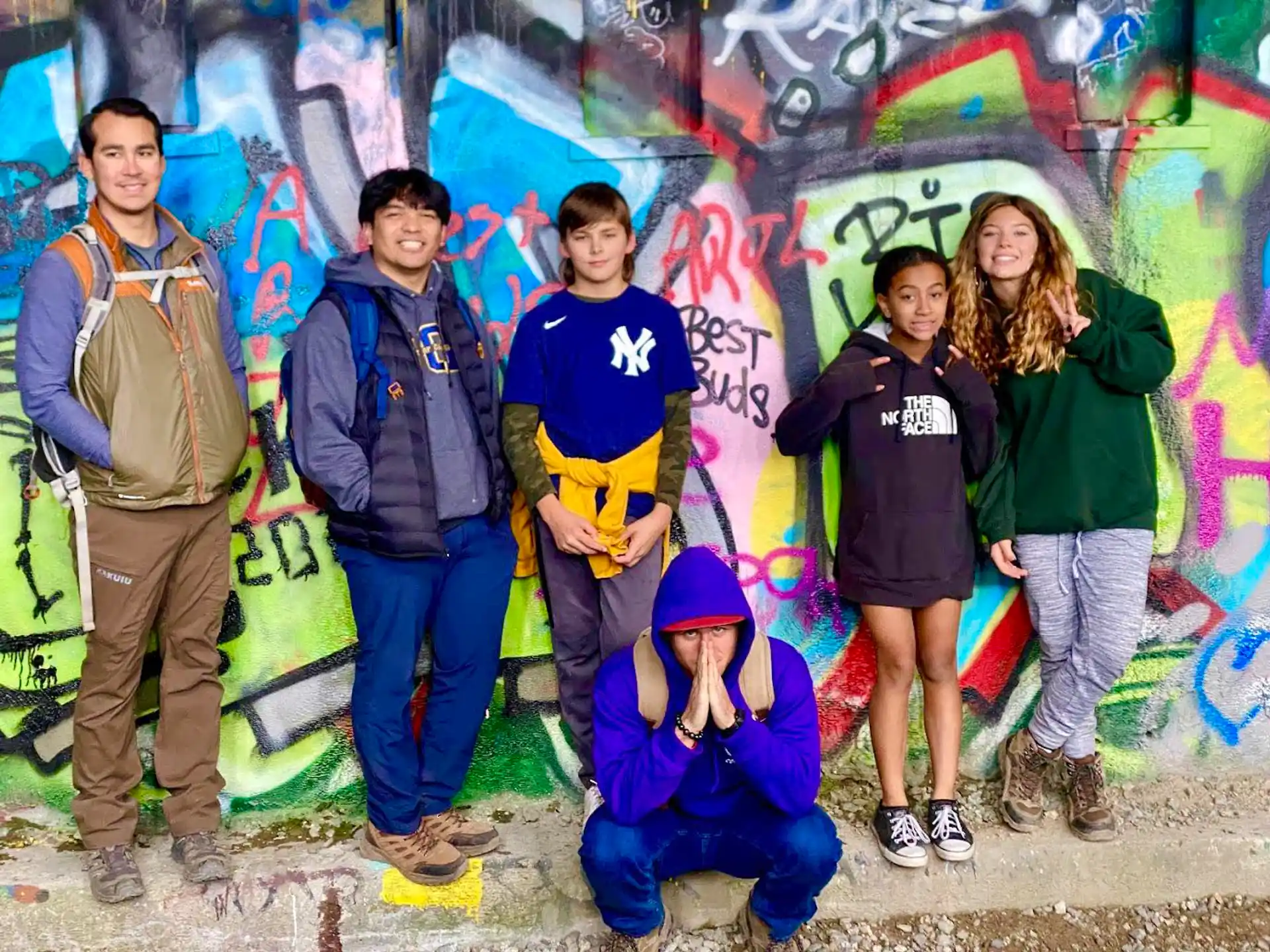 a group of people posing for a photo in front of a wall