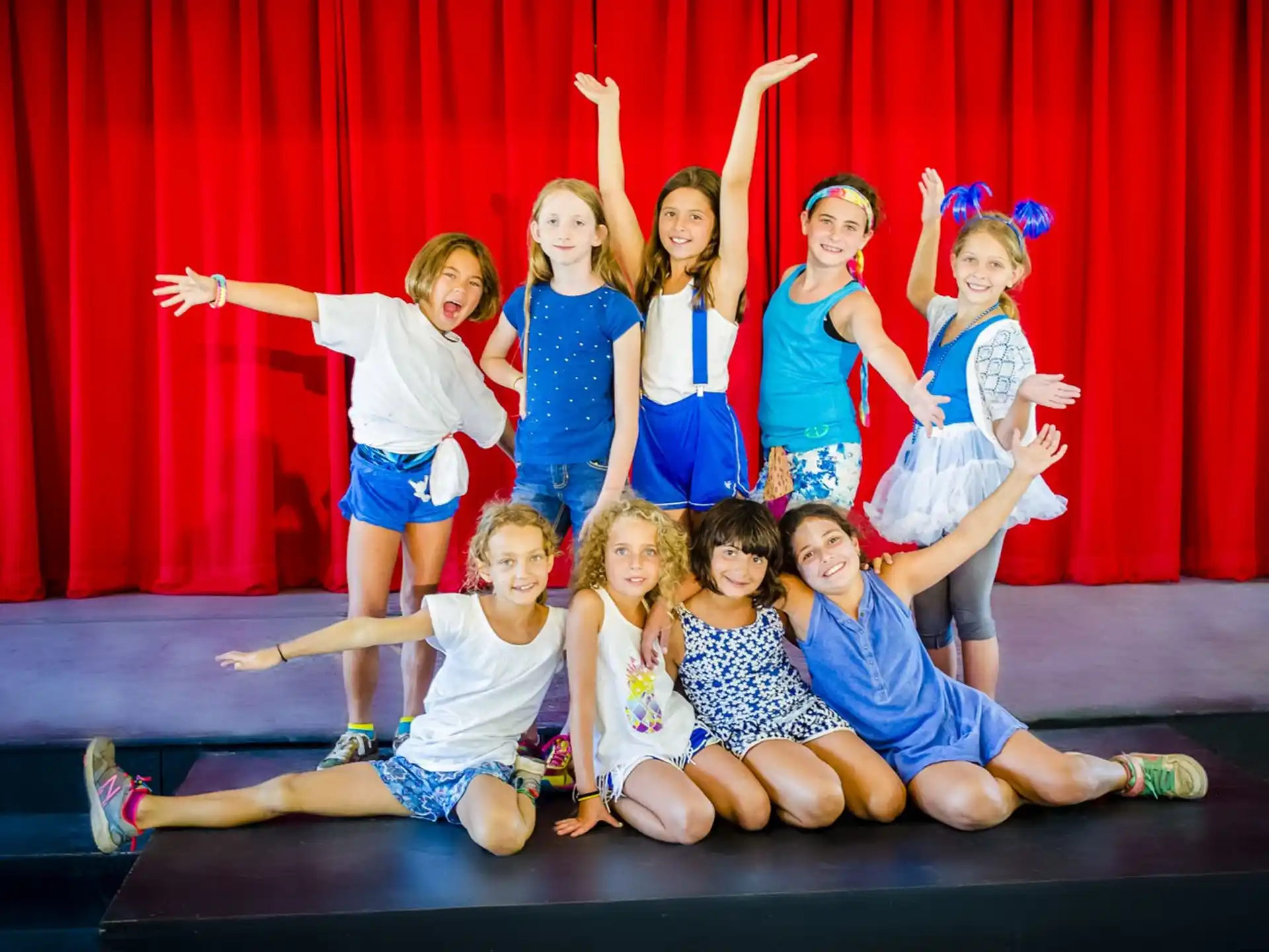 a group of girls posing for a photo on a stage