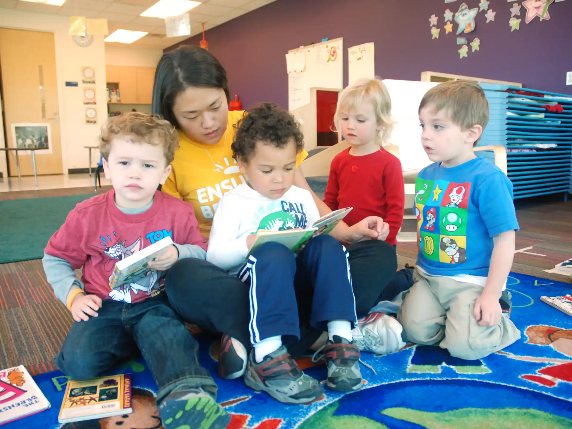 a group of children sitting on the floor playing a video game