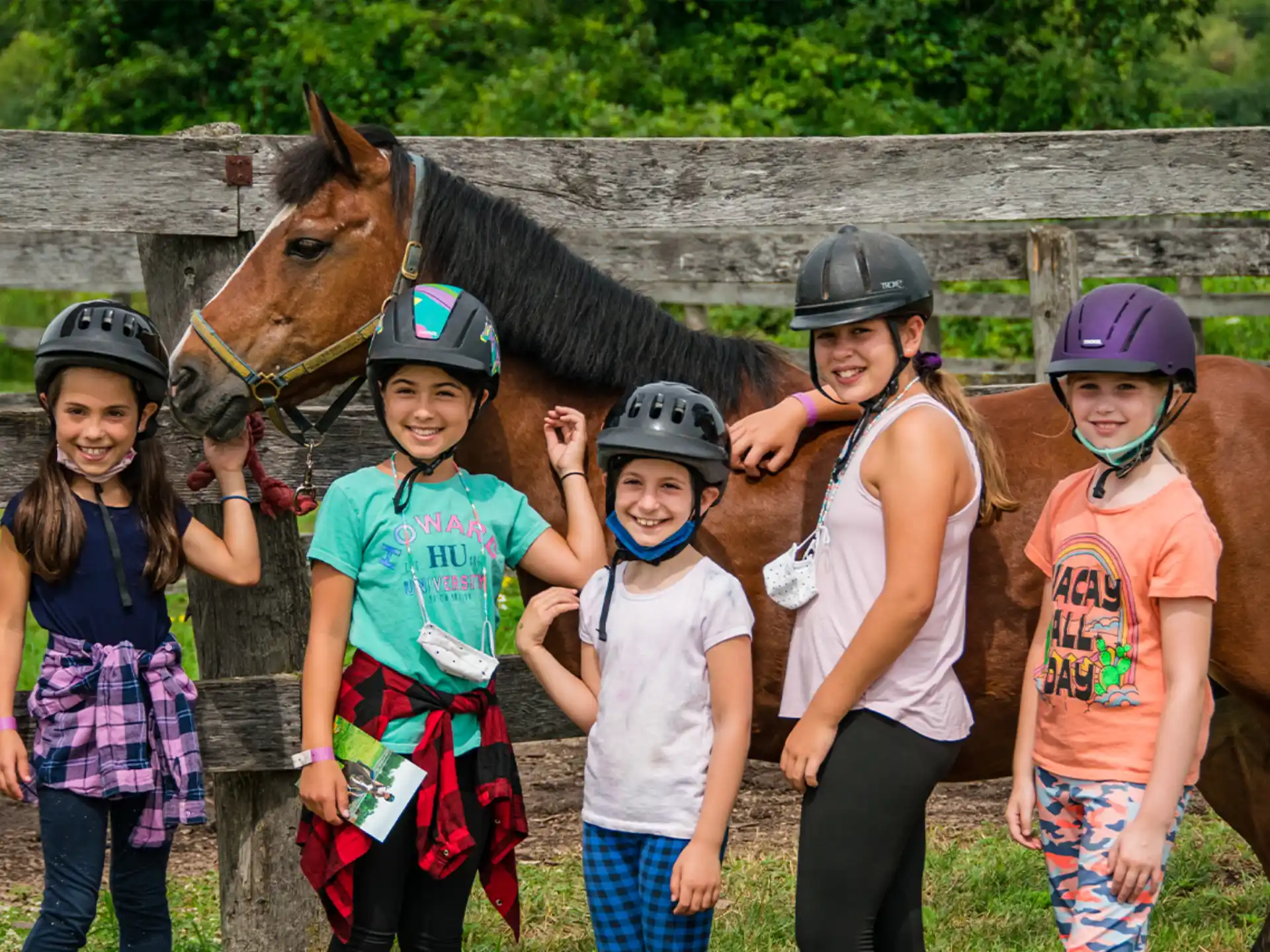 a group of children posing with a horse