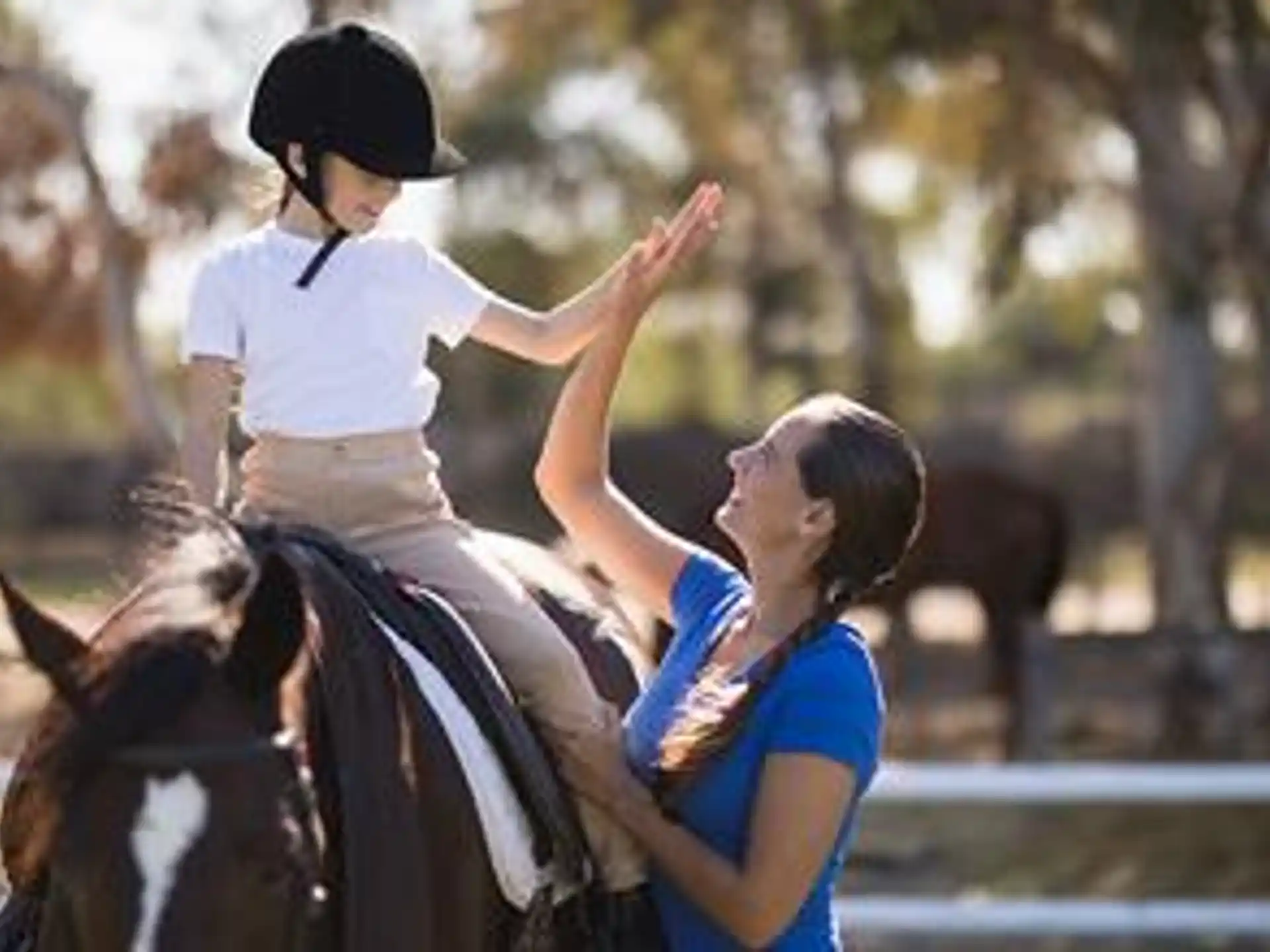 a woman riding a horse with a child on the back