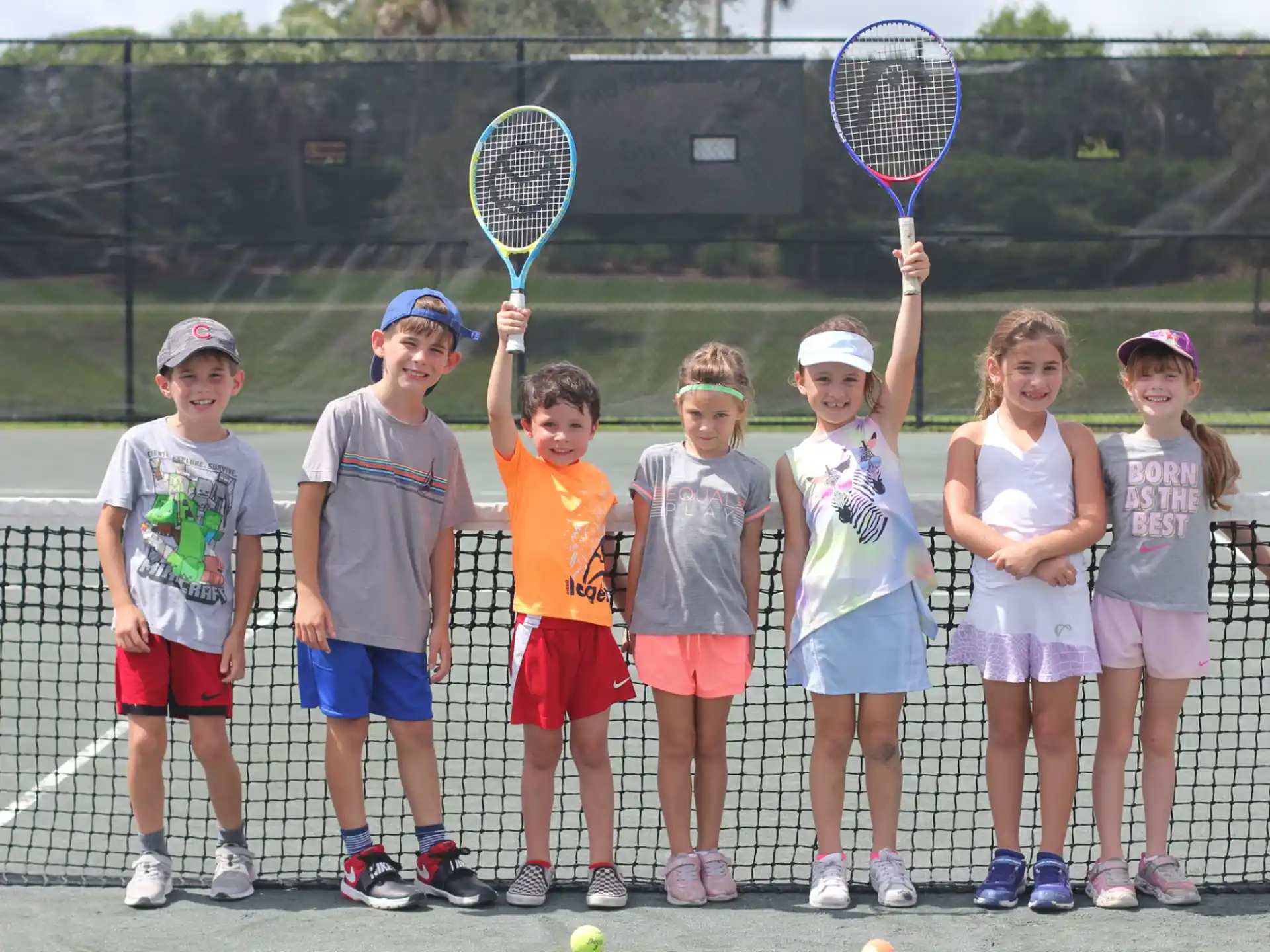 a group of kids holding tennis rackets