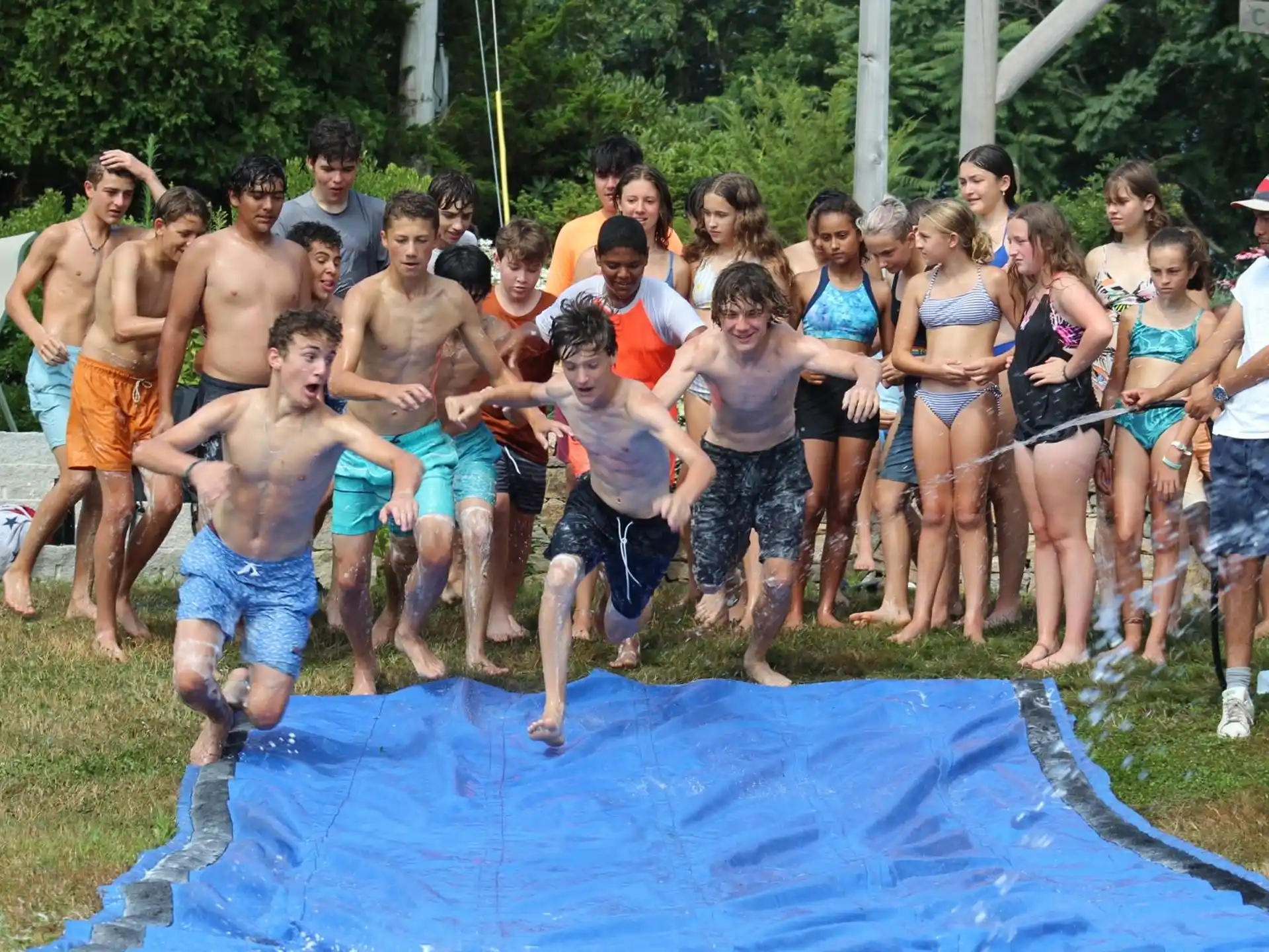 a group of people standing around a pool