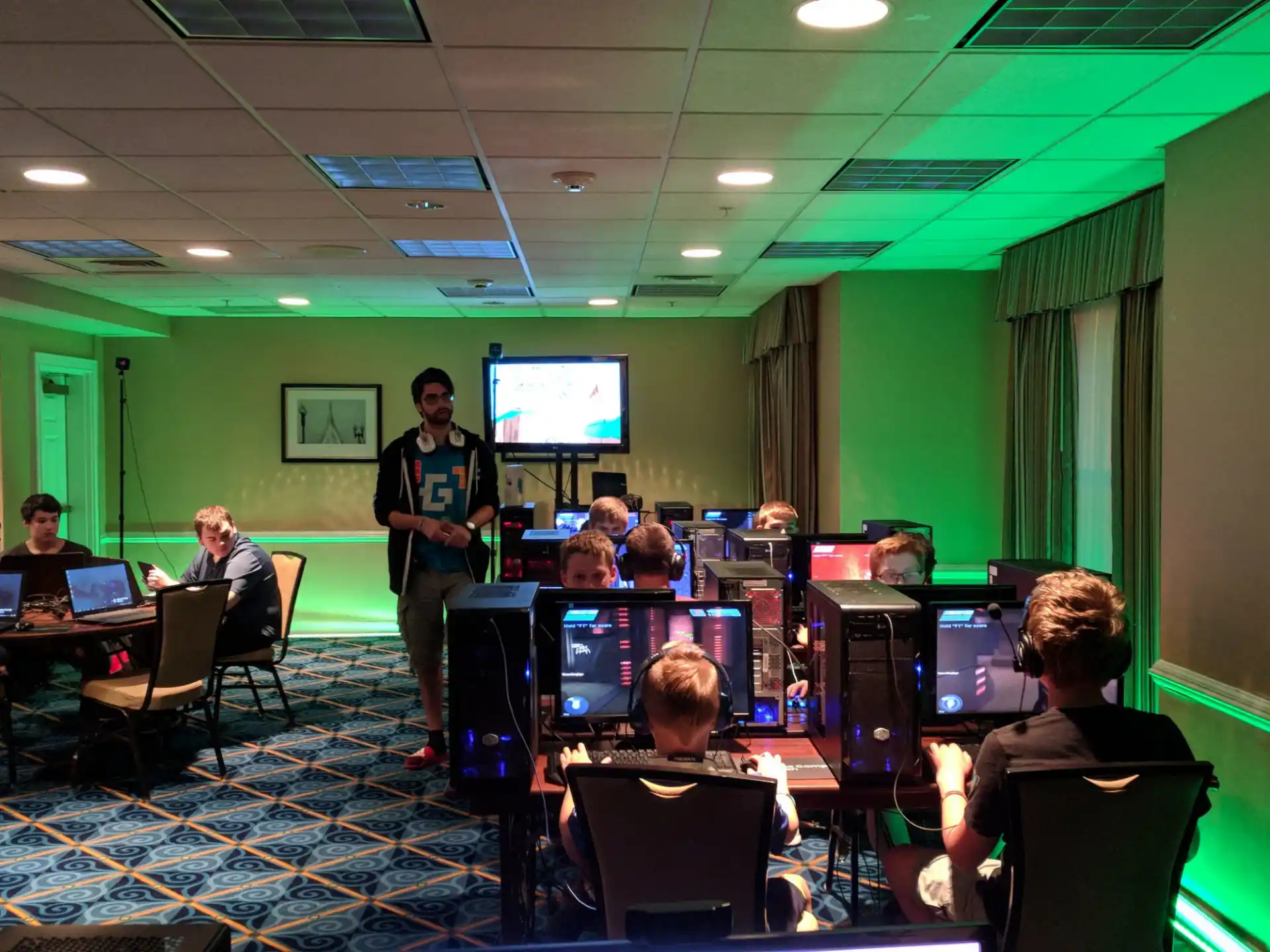 a person standing in front of a group of people sitting at computers