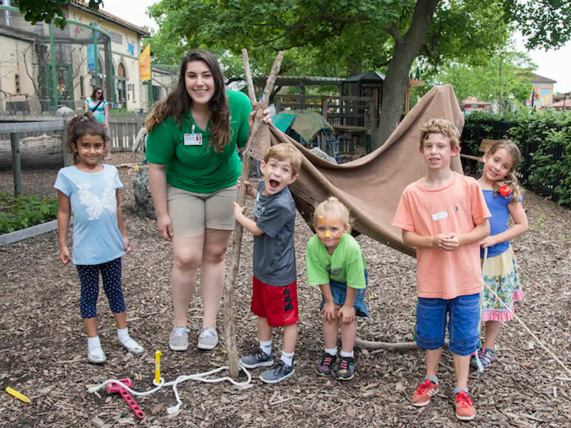 a group of children posing for a photo with a person in a garment